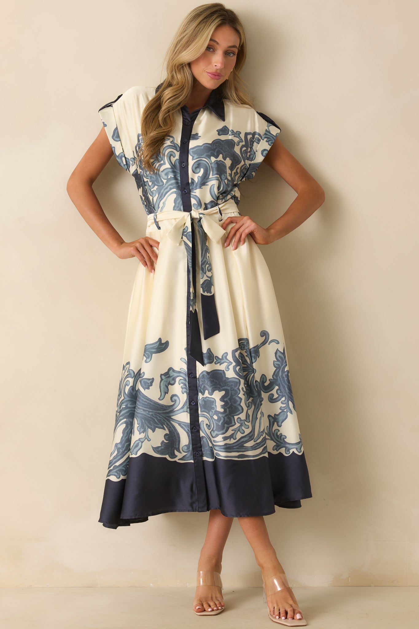 Full-length view showing cuffed sleeves, collared neckline, and ornate navy border print along the hemline.