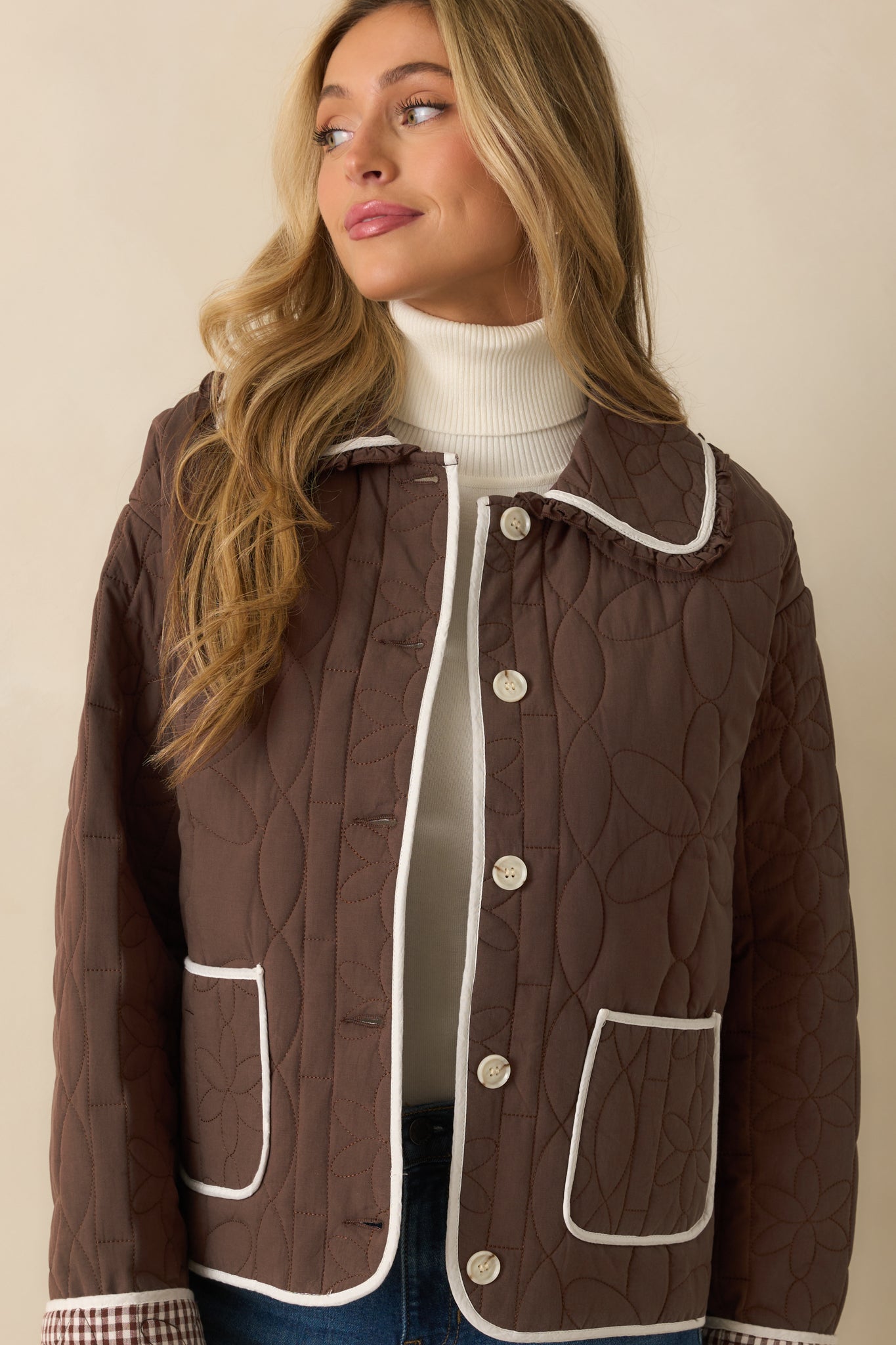 Detail of the functional patch pockets and ivory contrast trim along the front button closure.