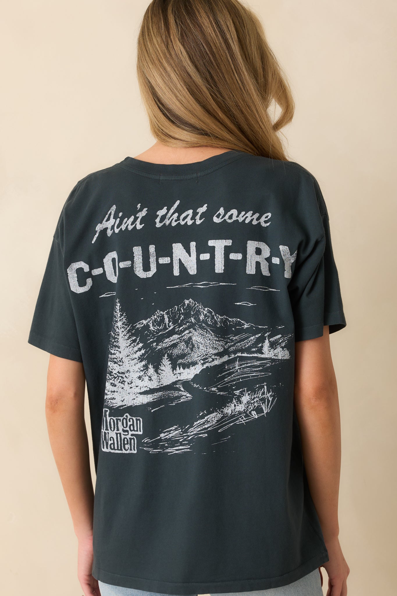 Rear view of black tee showing smooth cotton and straight hem finish.