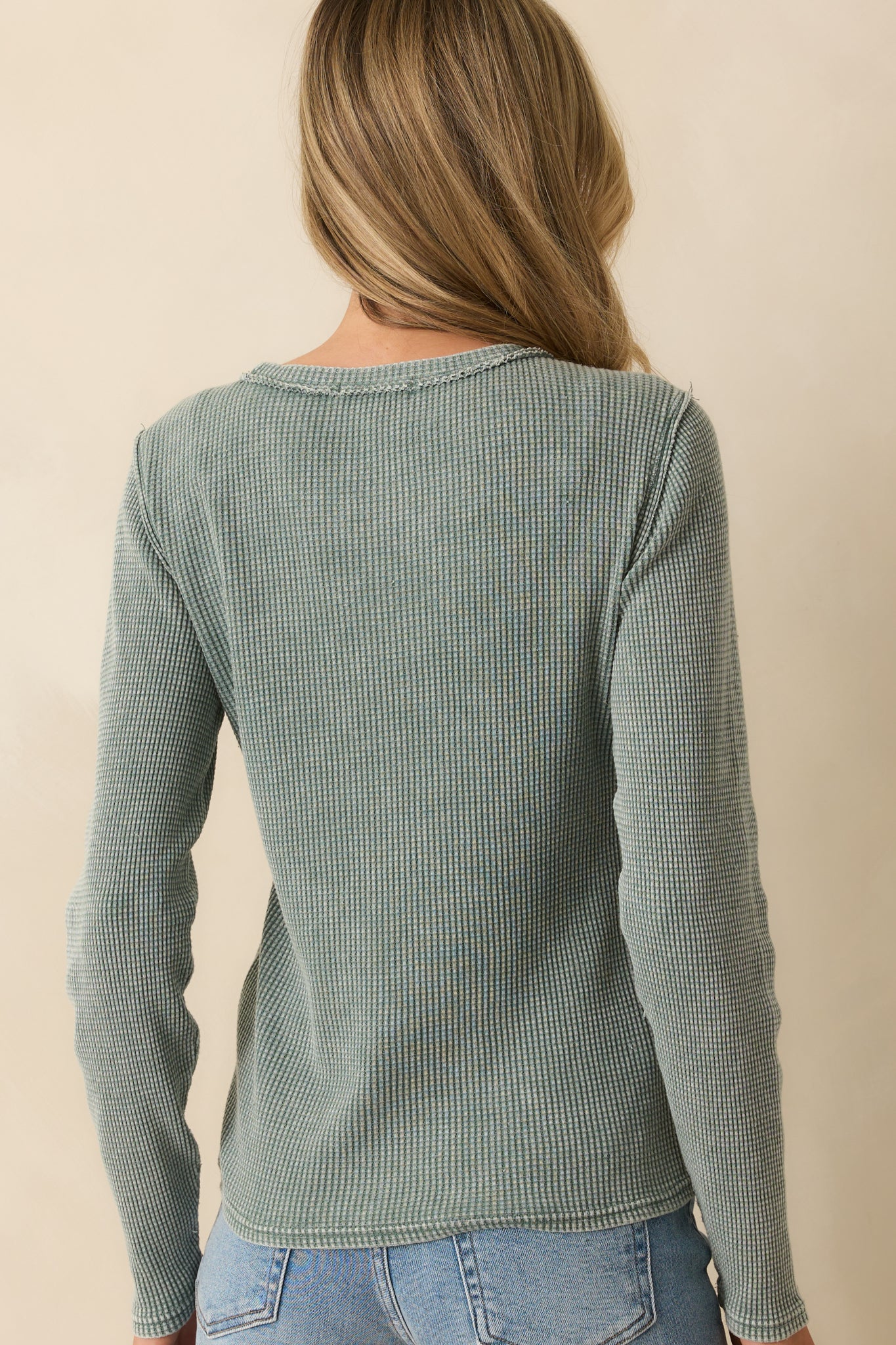 Rear view of sage green thermal top showing long sleeves, straight hem, and textured waffle knit.