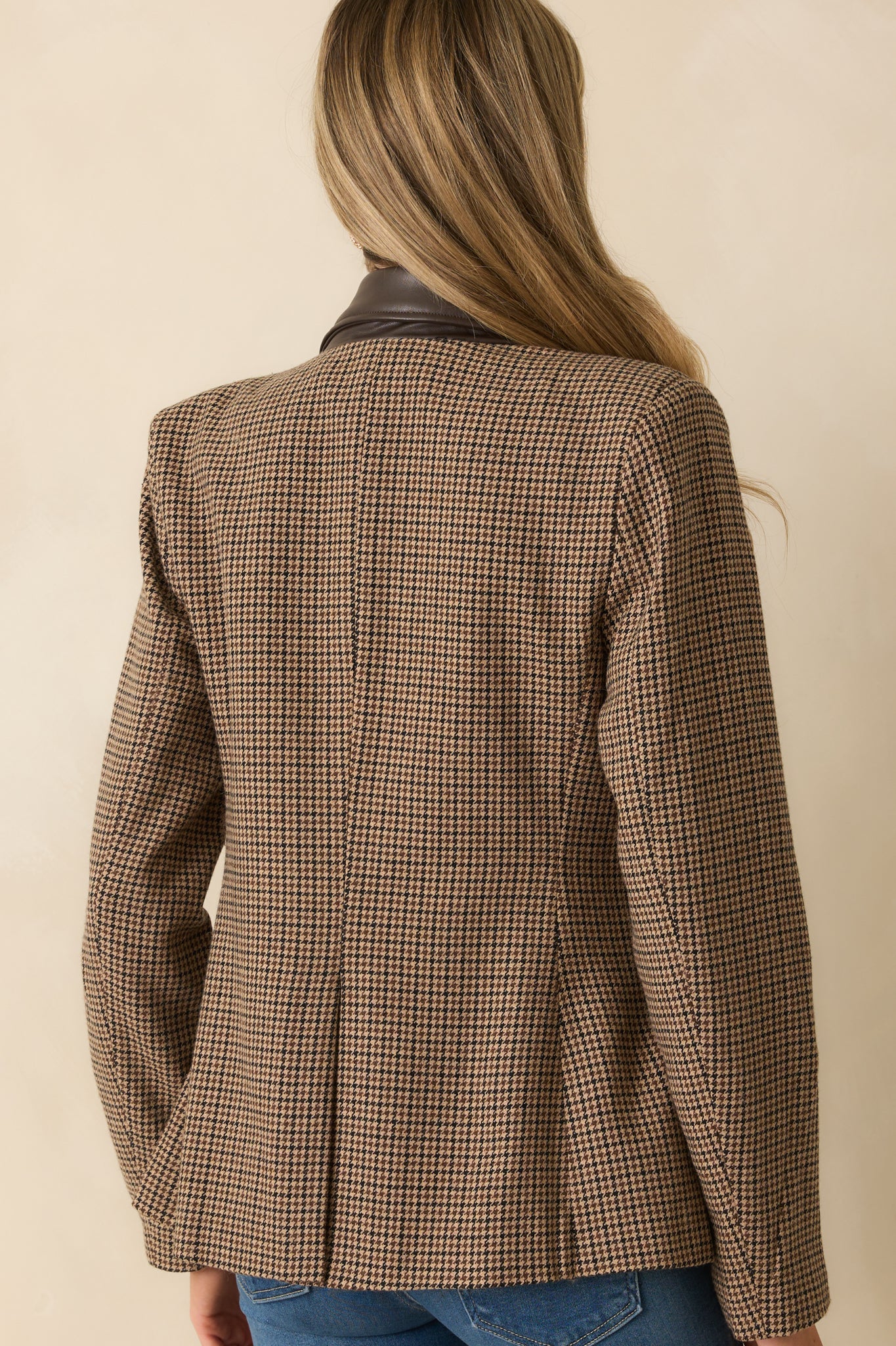 Rear view of the brown houndstooth blazer with straight hemline and long sleeves.