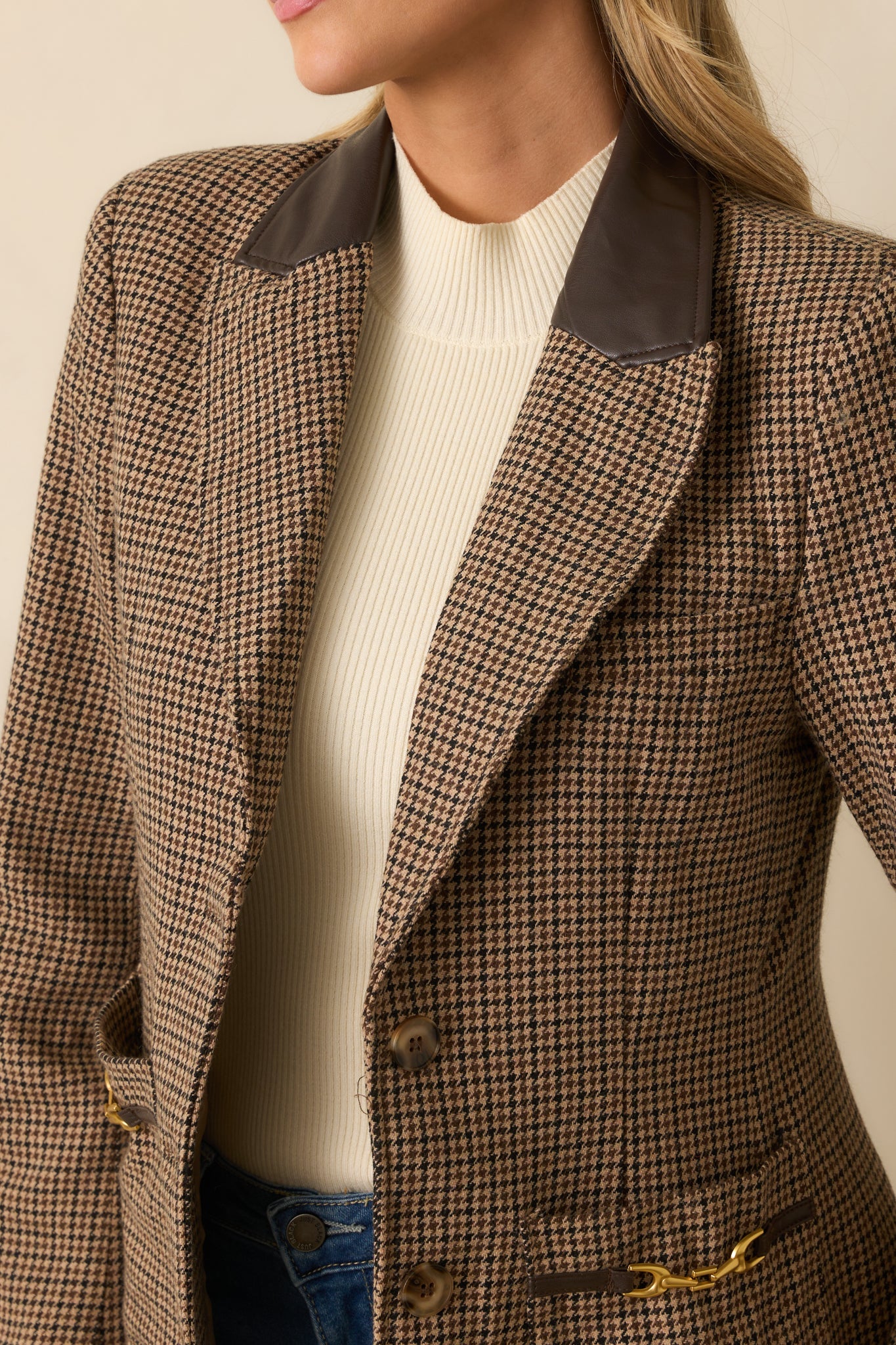 Close-up of the blazer’s faux leather notched collar and gold equestrian bit hardware, showcasing woven houndstooth texture.