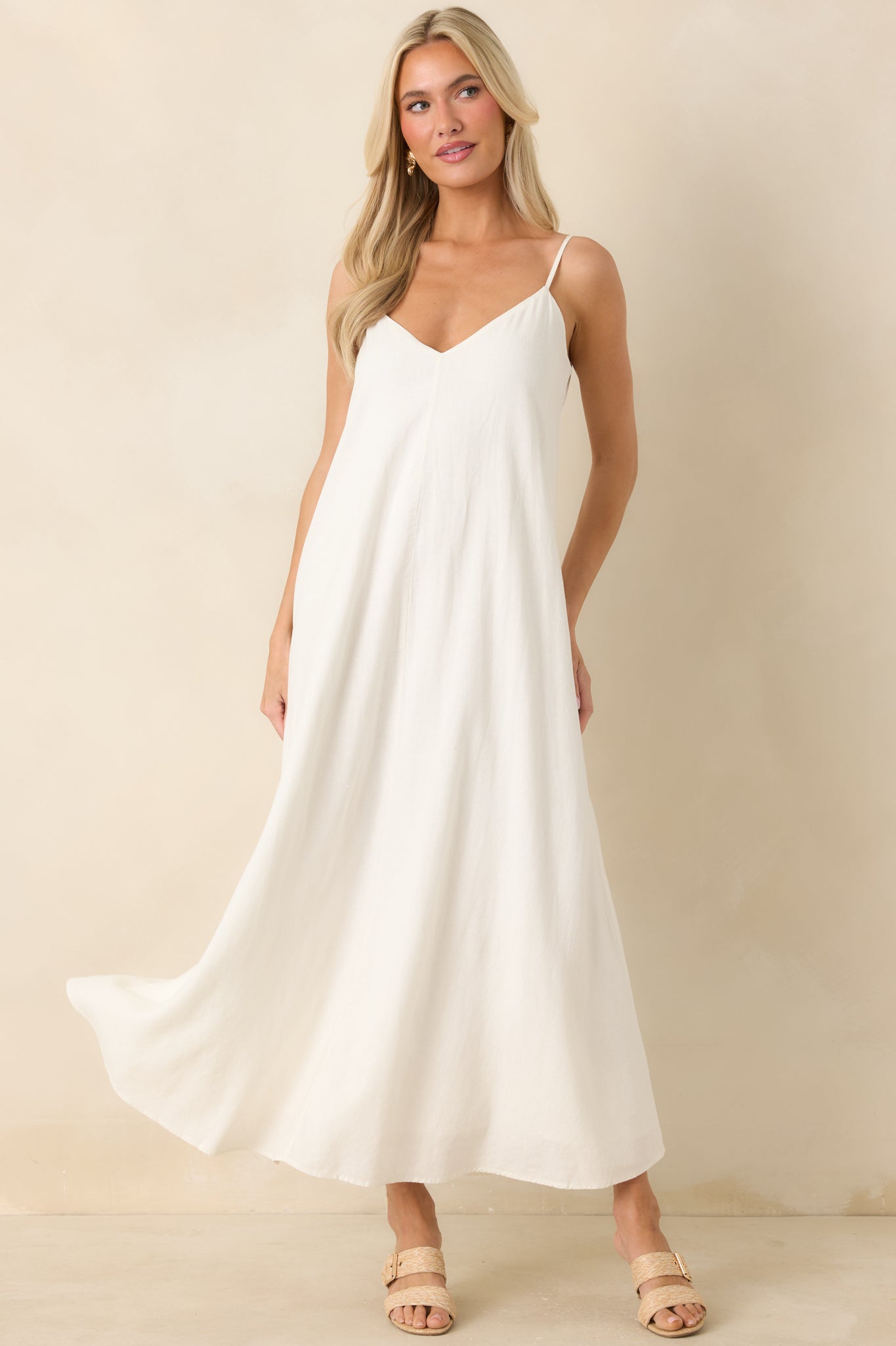 White linen blend midi dress featuring adjustable spaghetti straps, a v-neckline, and a soft relaxed flowy fit.

