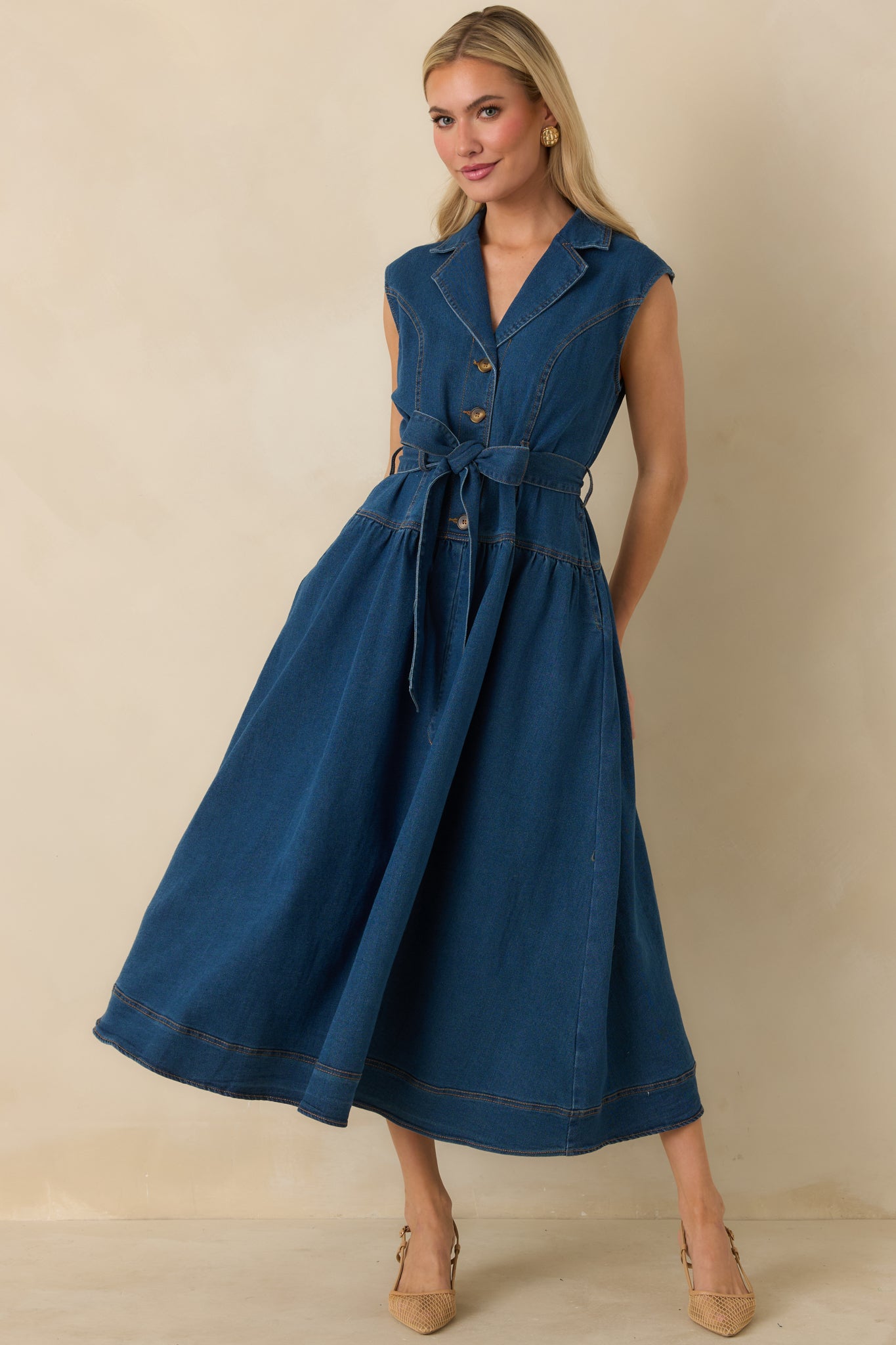 A-line denim midi dress with sleeveless silhouette, functional buttons, side pockets, and gathered skirt volume.
