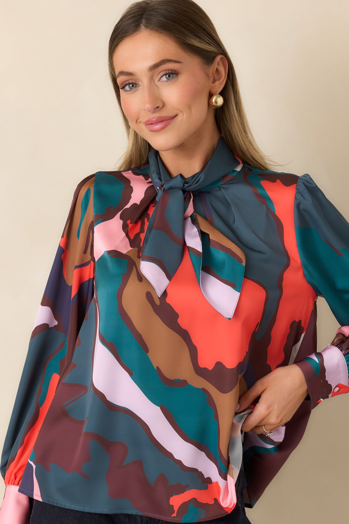 Voluminous puff shoulder and long sleeve in a multicolor abstract print.