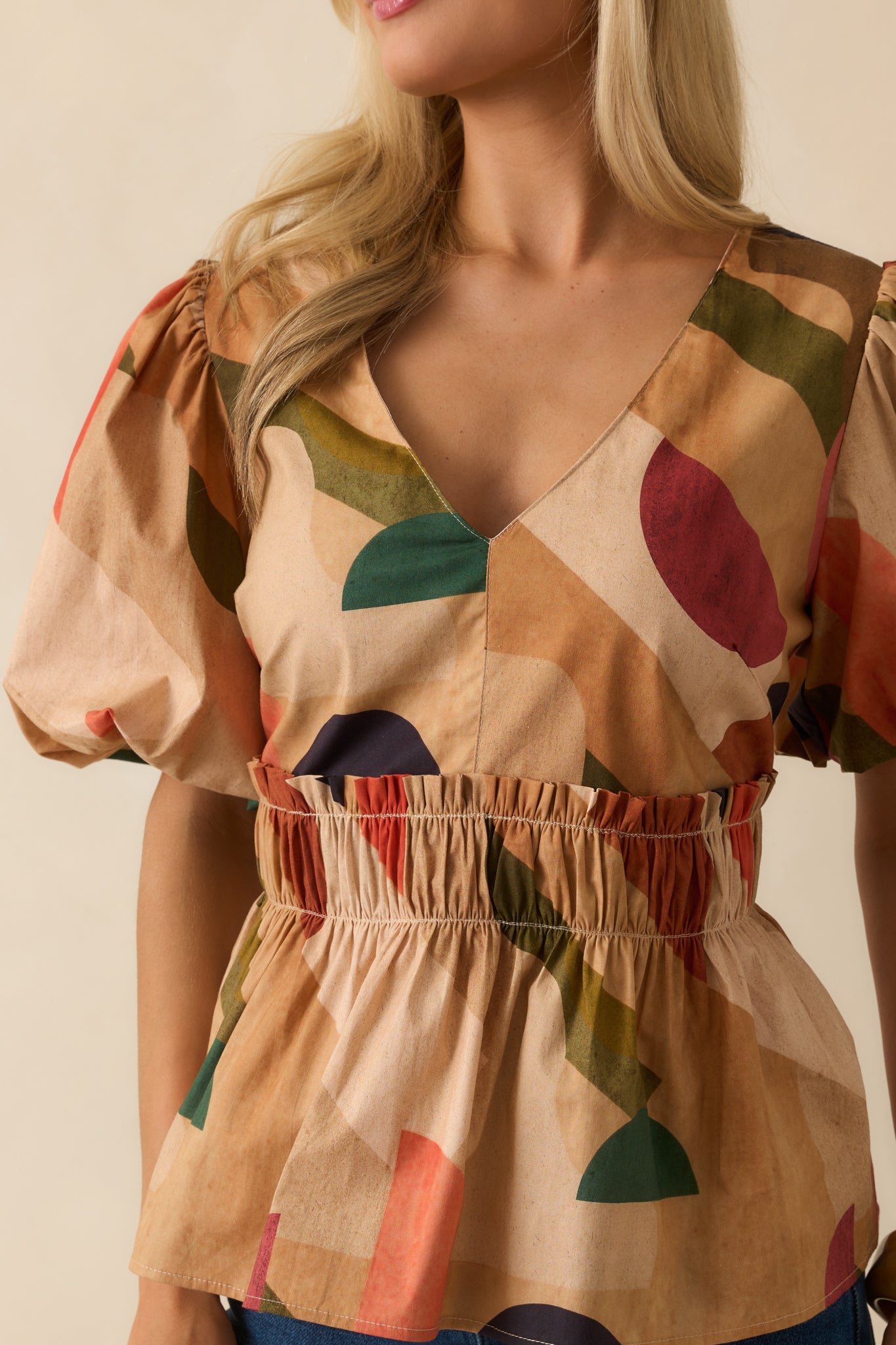 Detailed view of the abstract print fabric and smocked waist texture.