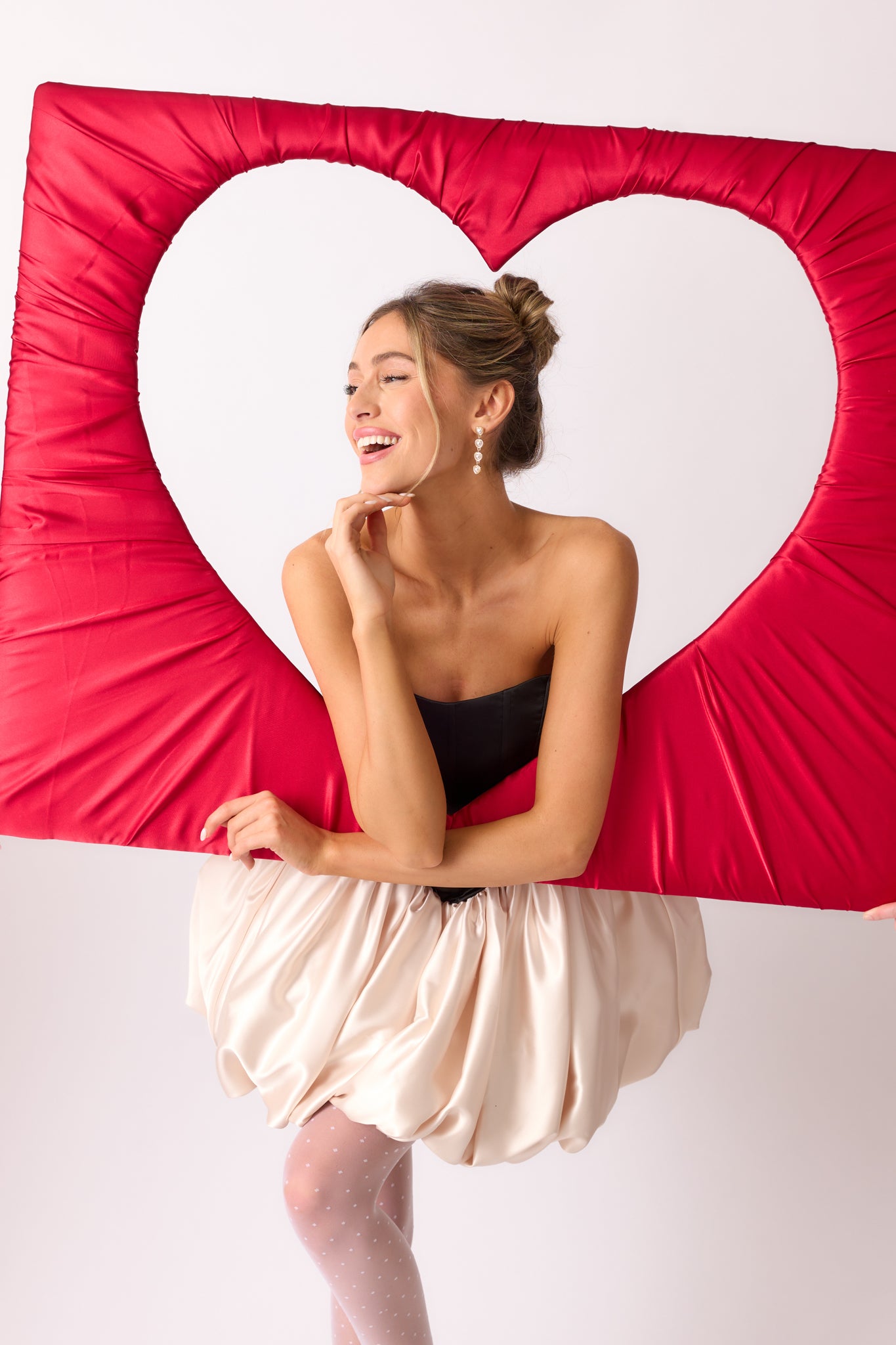 A bold action shot emphasizing the voluminous ivory bubble skirt and strapless design.