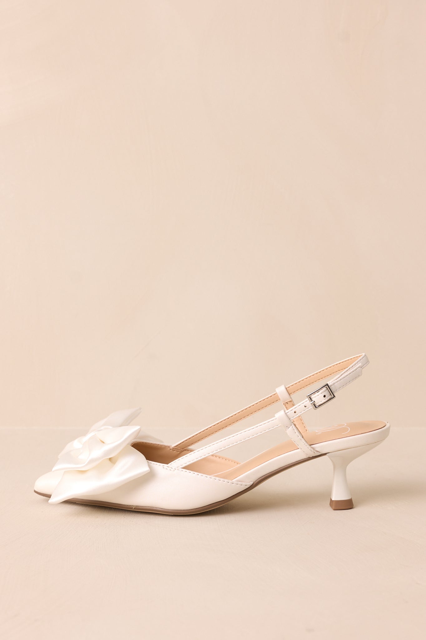 The adjustable slingback strap and short kitten heel add both elegance and comfort to this white satin-accented shoe.