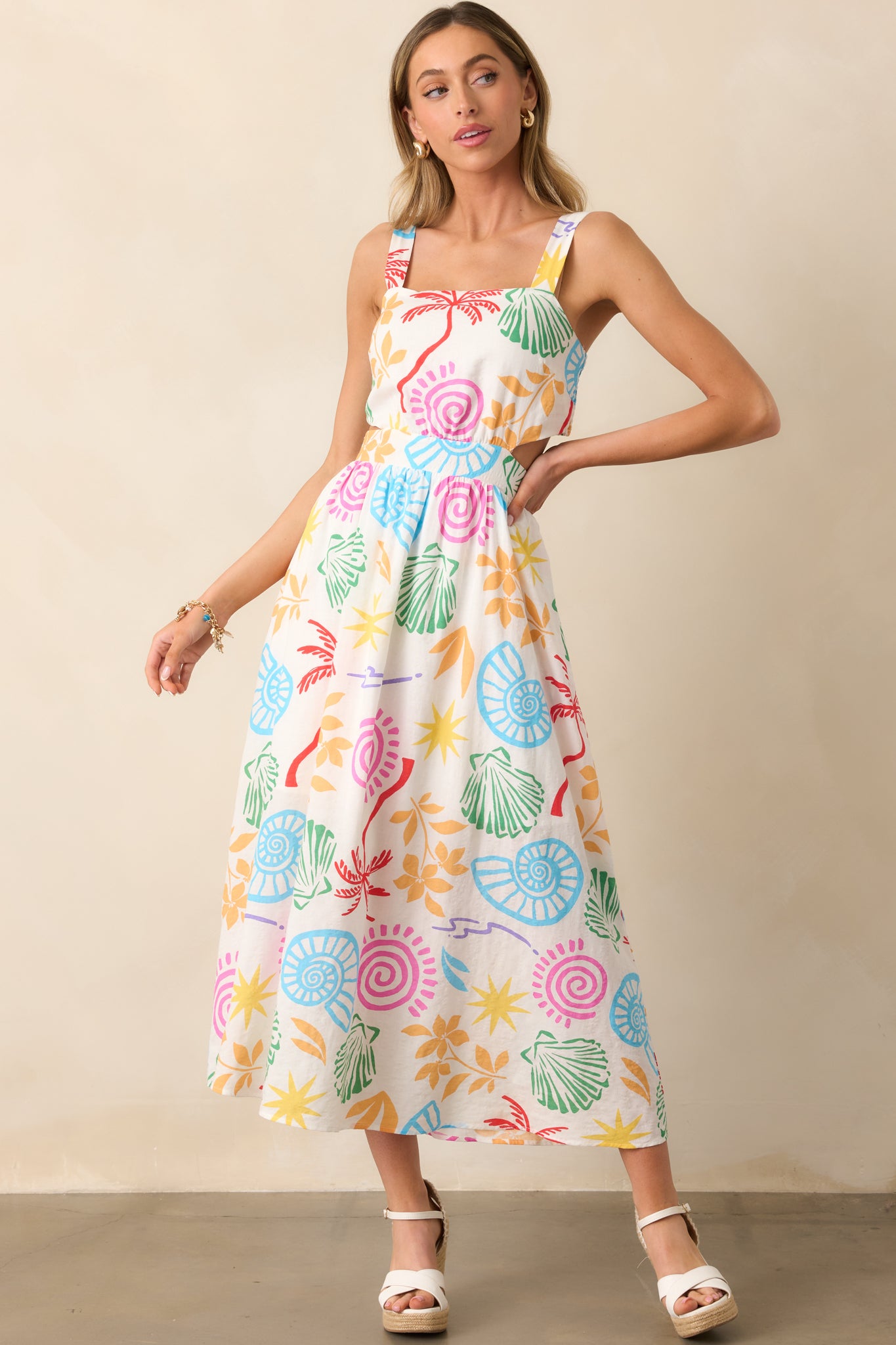 Airy ivory maxi dress with a bold tropical print, complete with a structured square neckline and flowy drape.