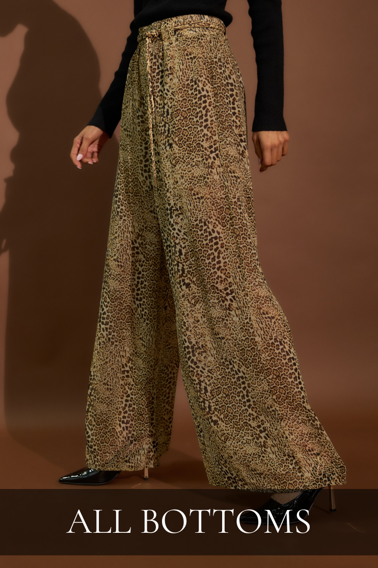 Women’s boutique bottoms featuring flowy leopard print wide leg pants styled with a classic black knit top.