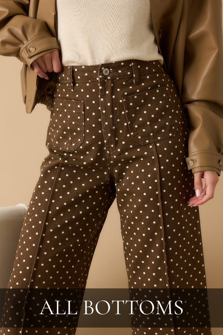Model wearing brown polka dot pants and a brown leather jacket. All Bottoms.