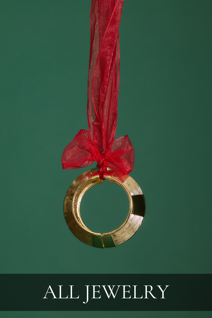 Gold statement bracelet tied with a red ribbon, showcasing elegant and festive accessories from the All Jewelry collection for women’s holiday style.