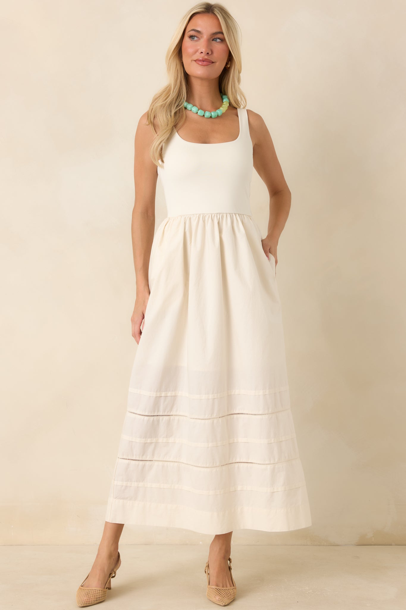 Thoughtful details like side pockets and subtle horizontal inset panels near the hem add texture and dimension to this timeless design.