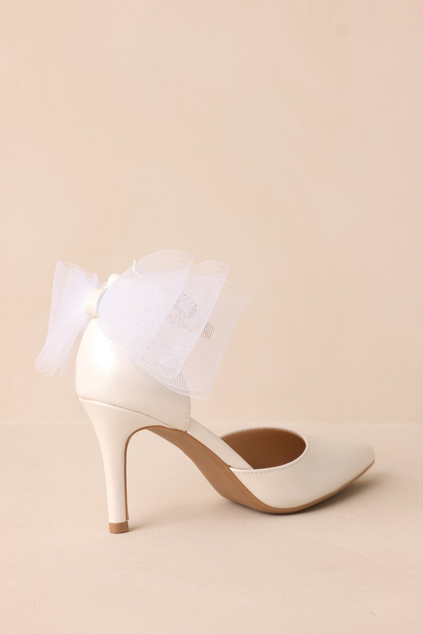 Another angled view of the back showcasing the thin heel and lace bow.