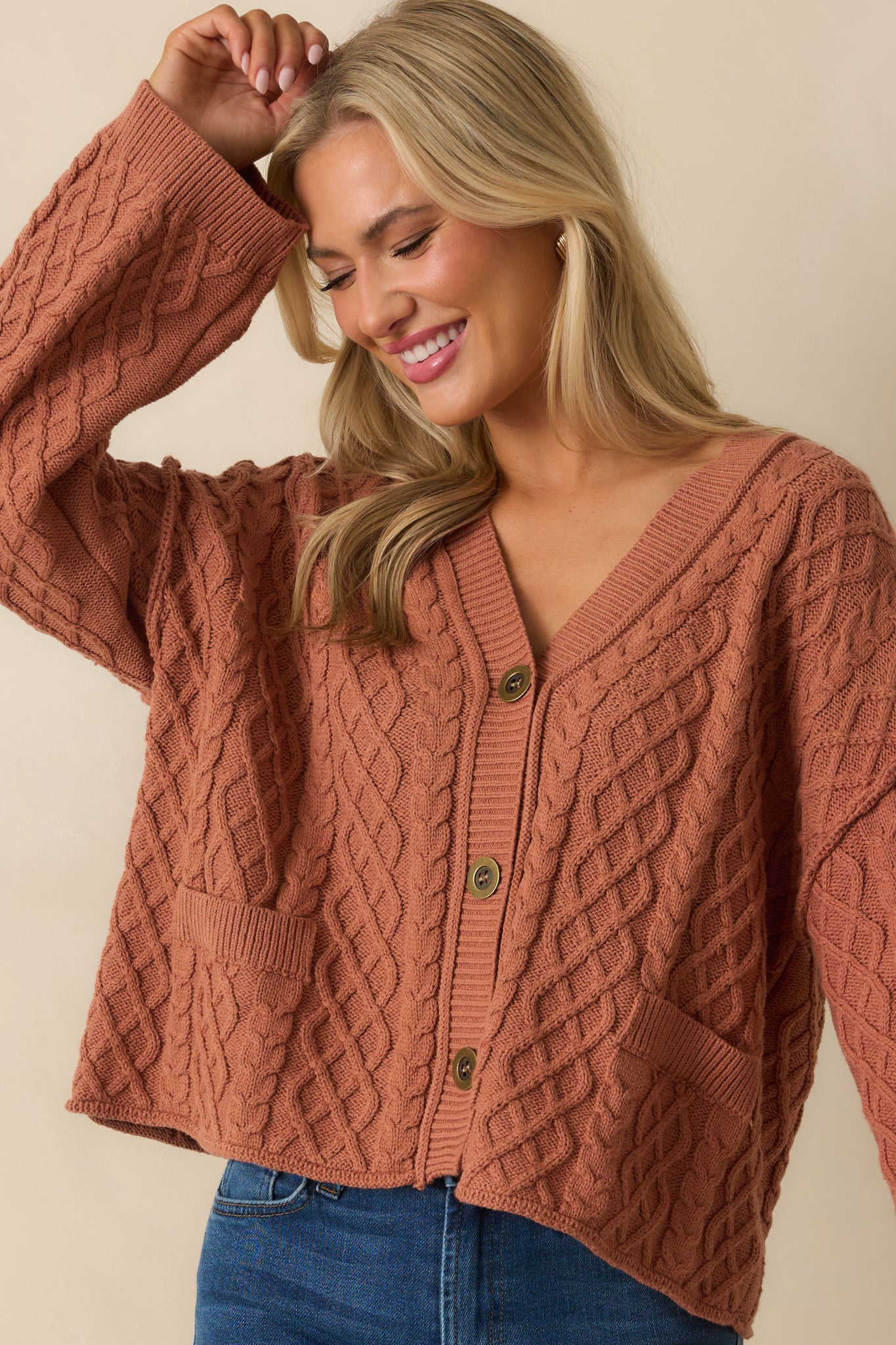An angled cropped view showcasing the v-neckline, faux pockets, and top buttons.