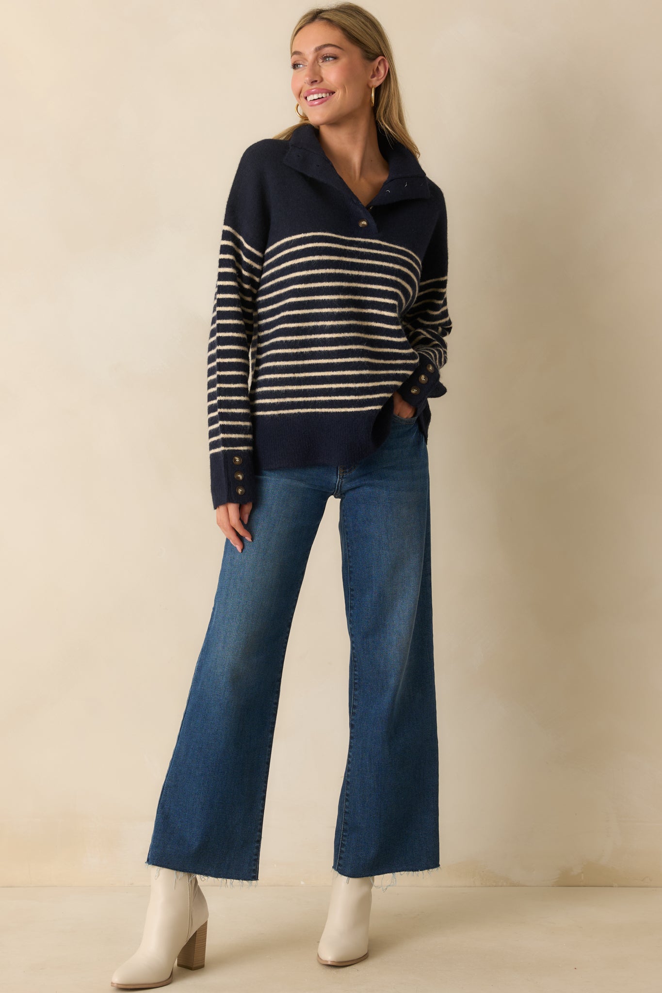 A front-facing angled view showing the long sleeves, ribbed hem, and functional button cuffs.