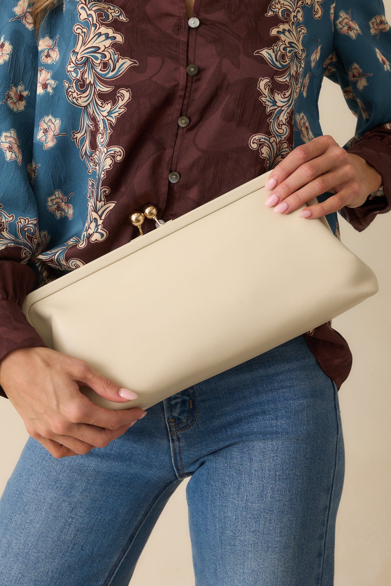 An angled front view highlighting the structured shape and gold kiss-lock closure.