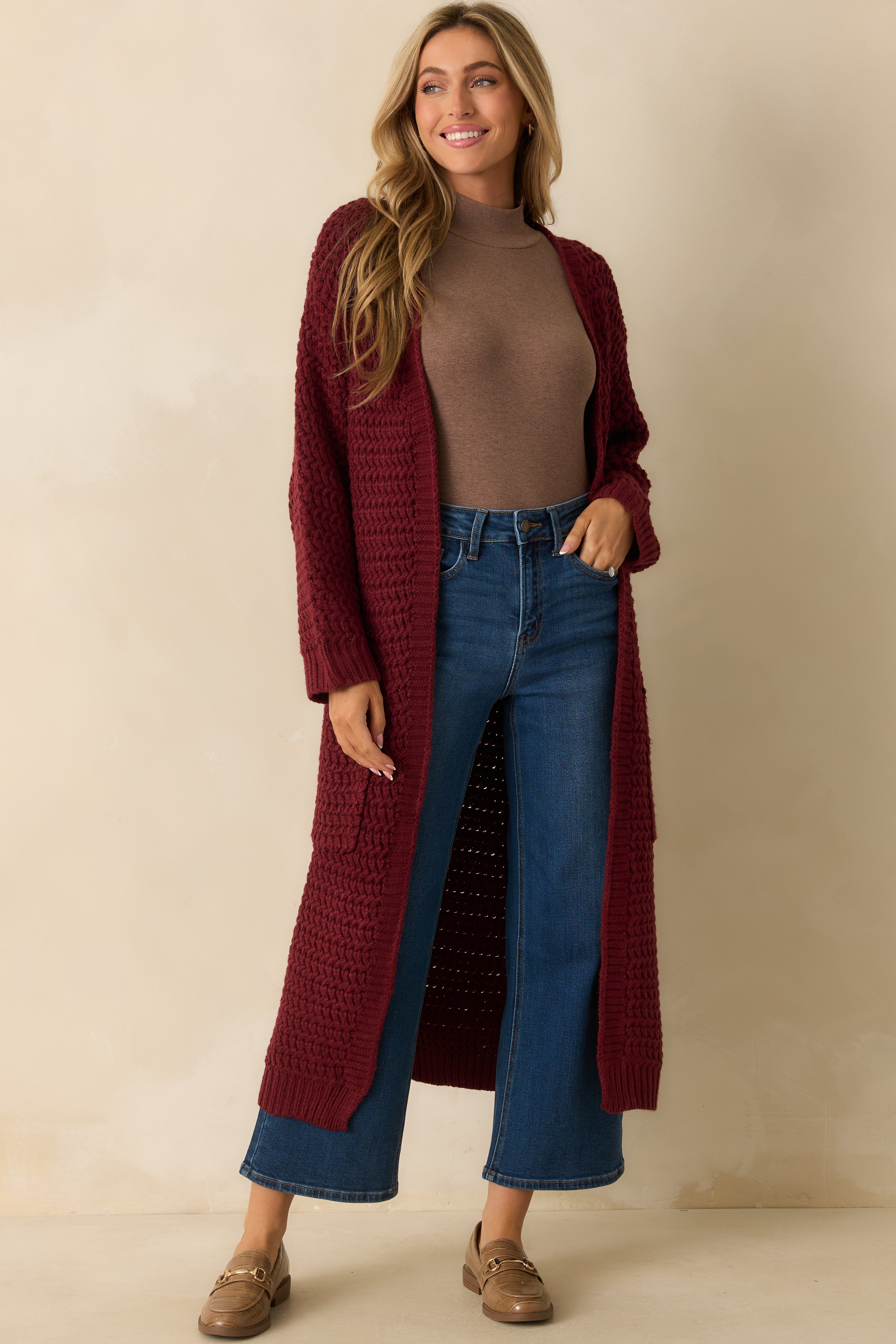 Angled front view showing the chunky textured knit and ribbed sleeve cuffs.