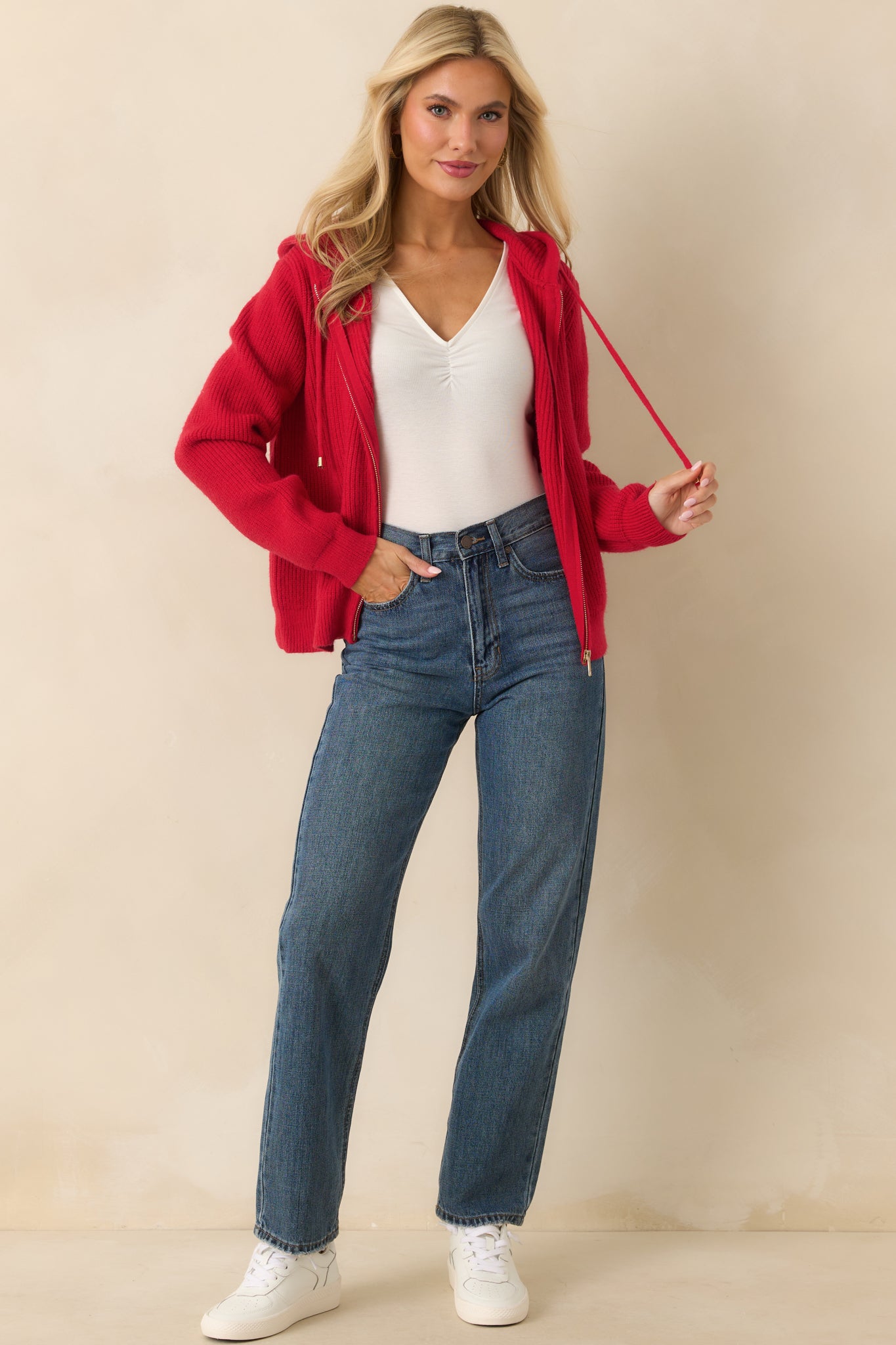 Angled full view of the red knit jacket showcasing long sleeves and relaxed fit.