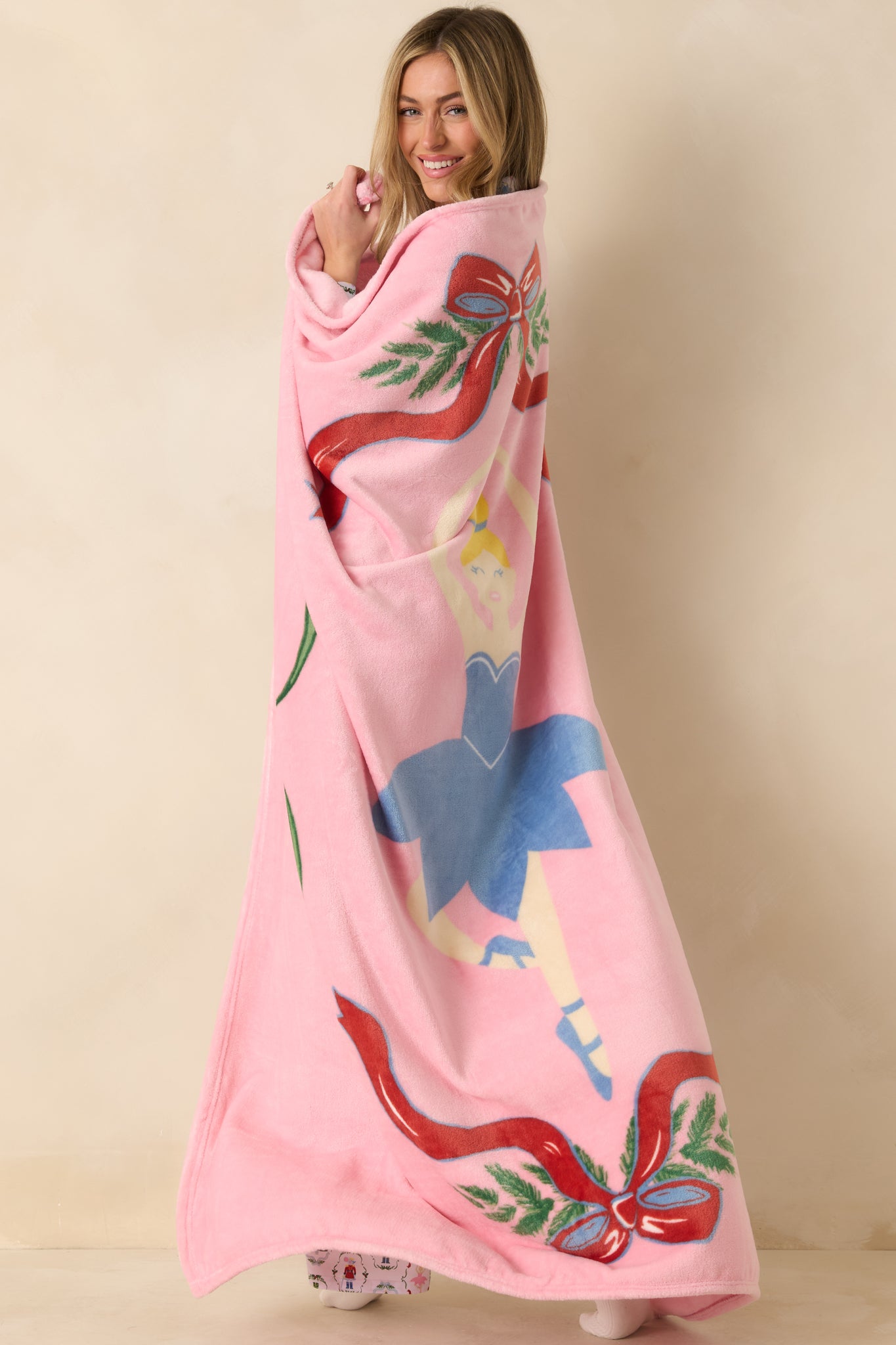 Angled side view focusing on the ballerina figure and decorative ribbon elements on the plush blanket.