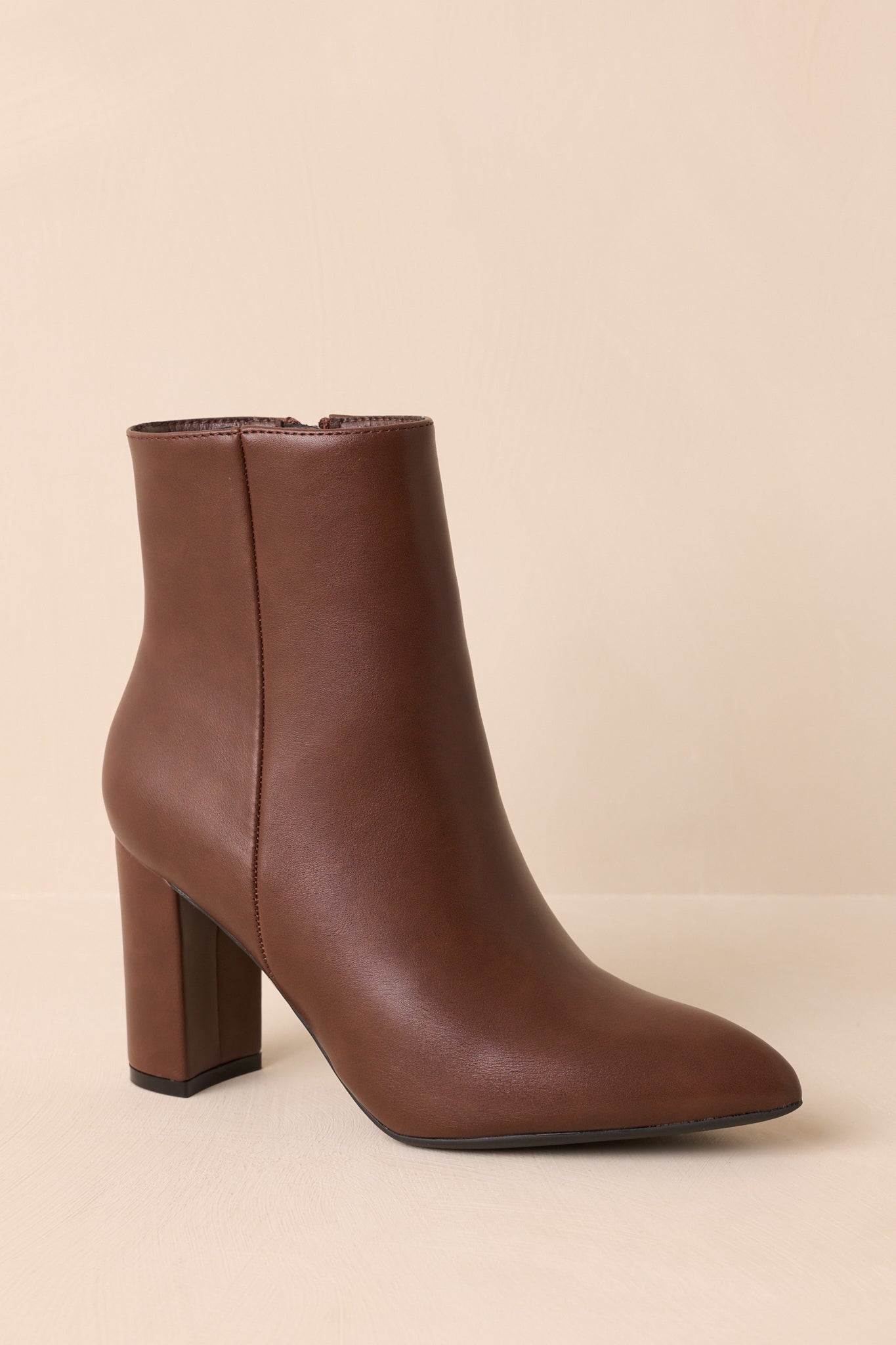 An angled front view highlighting the outer seam detail, block heel, and pointed toe. 