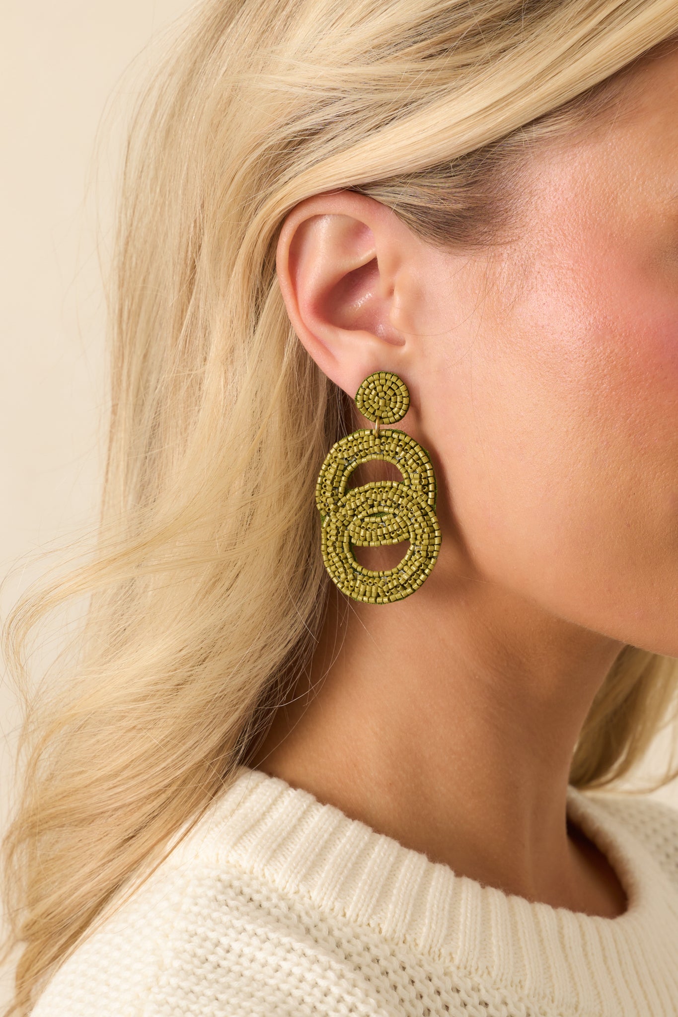 A cropped angled view showing the textured beaded design throughout the oval drops.