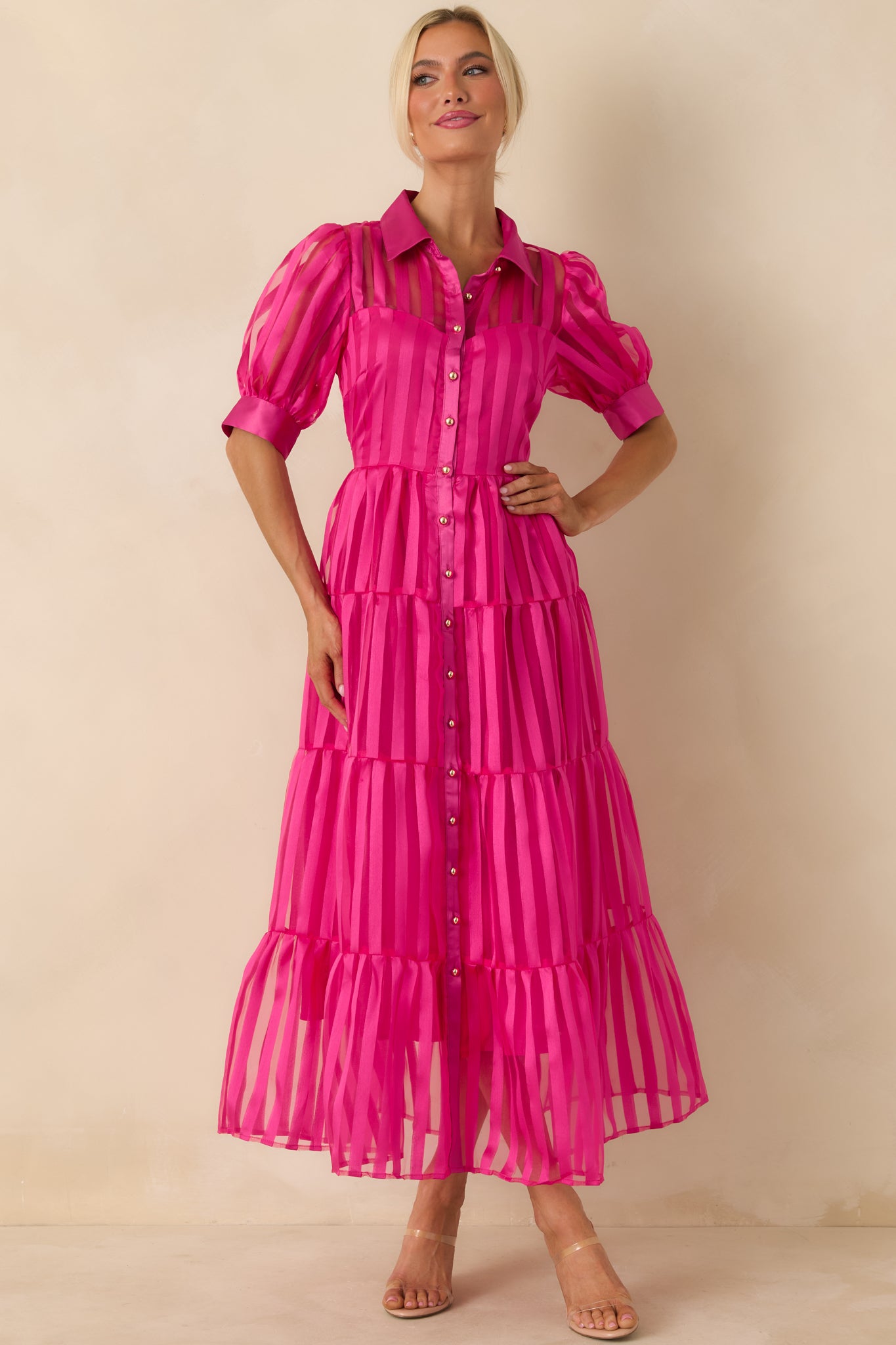 Ankle-length fuchsia pink dress in sheer striped fabric, designed with a fitted top, tiered skirt, and soft drape.