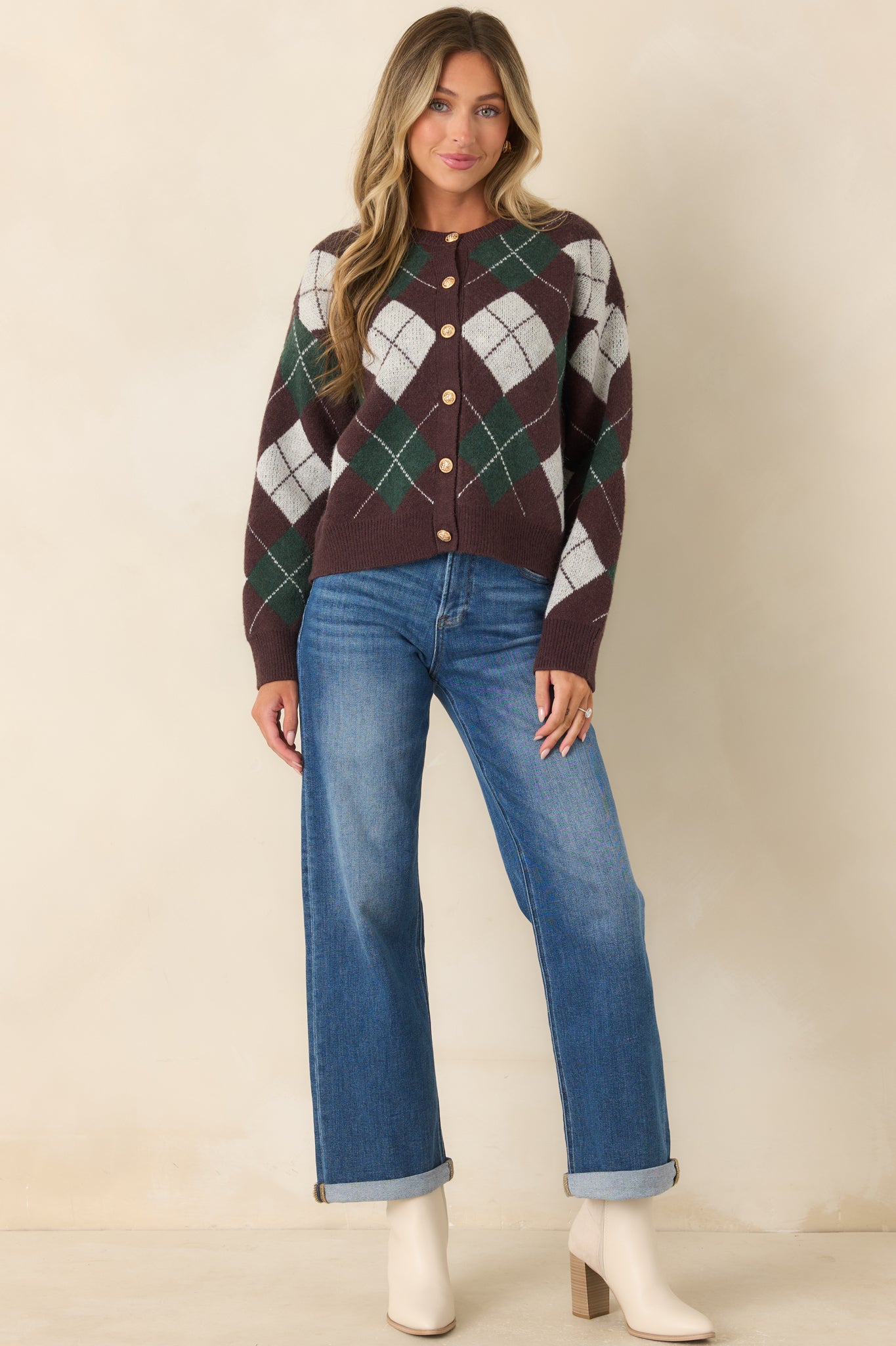 Brown, hunter green, and ivory argyle knit cardigan featuring a round neckline, gold-tone button-front closure, and relaxed silhouette.