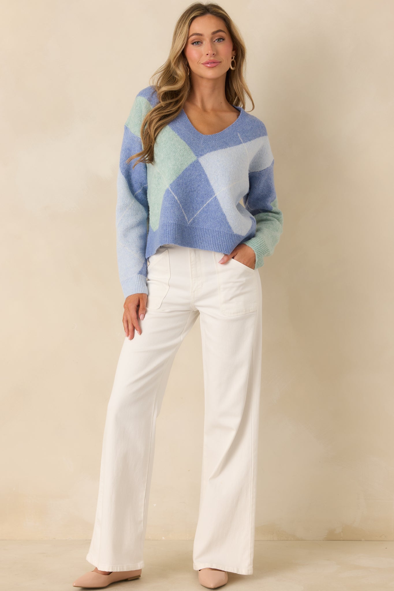 Front-facing view of argyle knit sweater featuring contrasting blue and green tones and long sleeves.