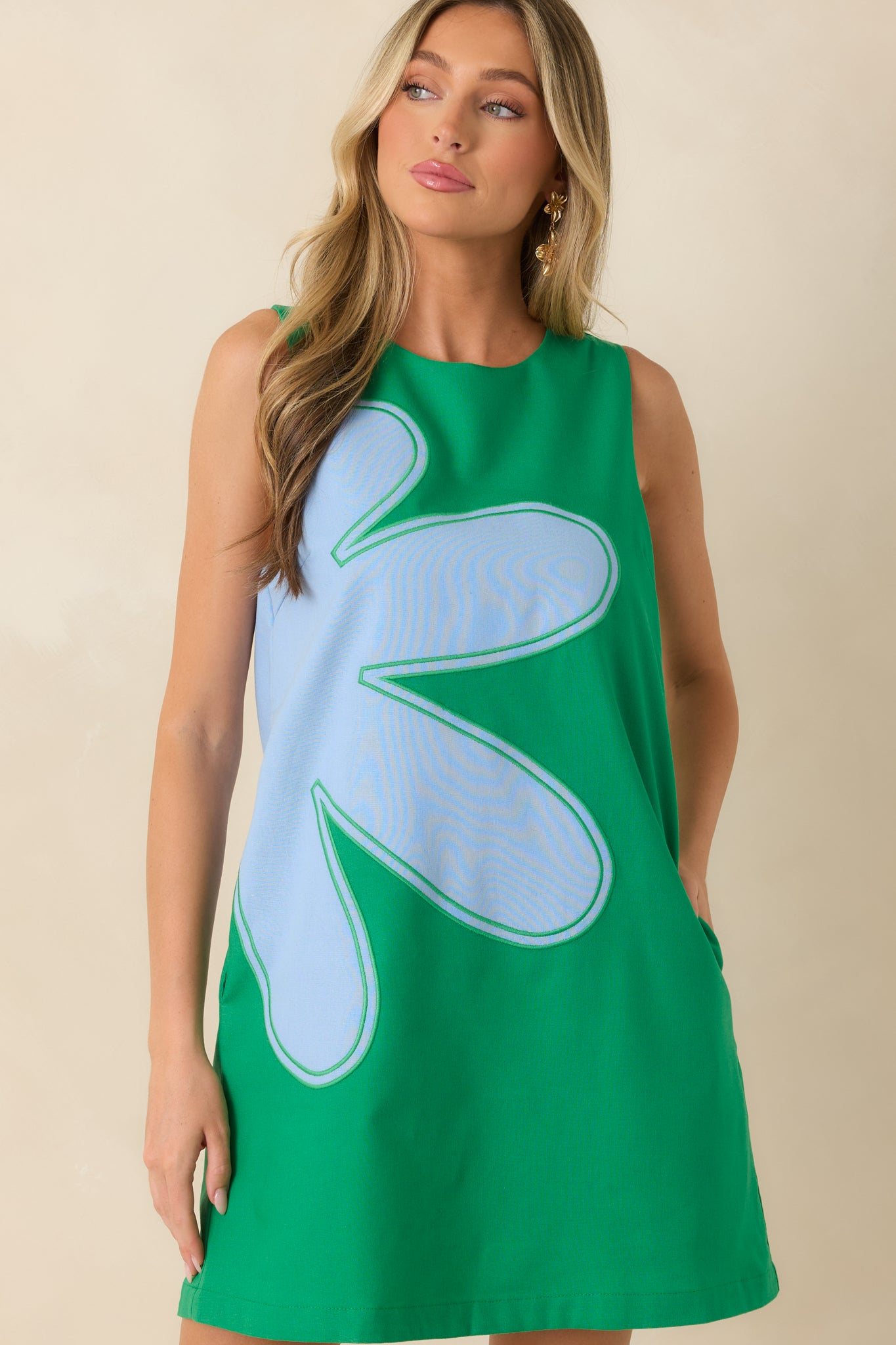 Detailed view of the artistic floral embellishments and relaxed silhouette of the mini dress.