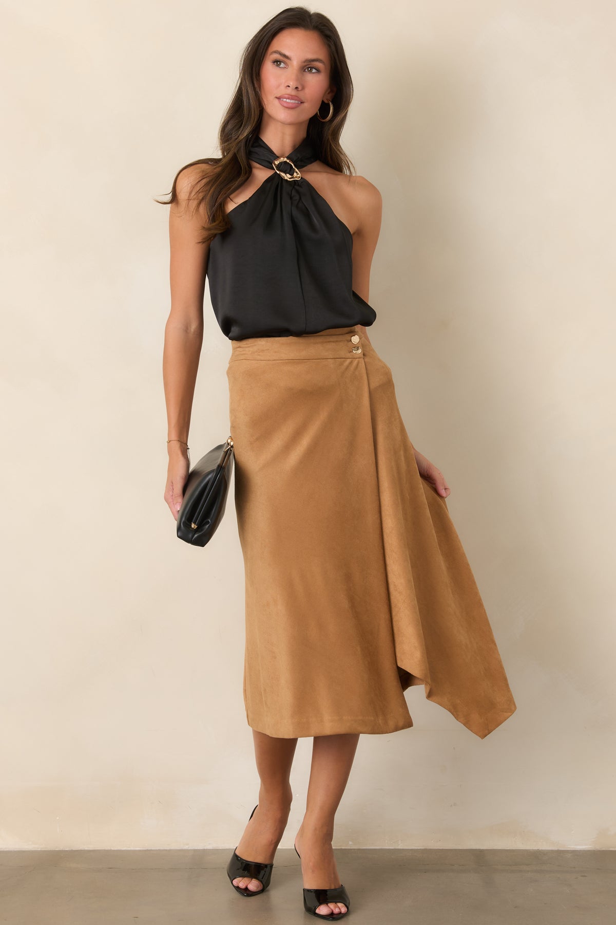 Asymmetrical wrap front gives the faux suede skirt a polished look, finished with hammered gold-tone buttons.