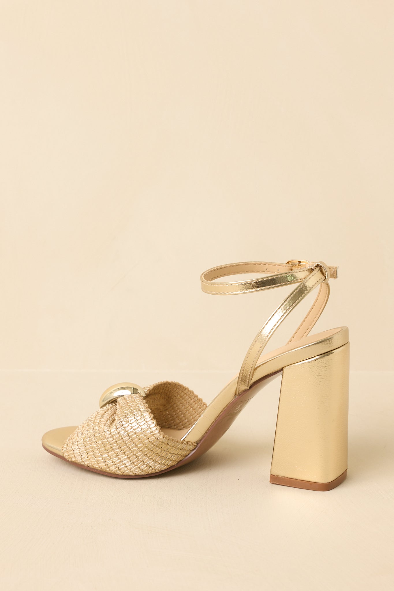 Back angled view showing the metallic block heel, adjustable ankle strap, and woven detailing on the sandals.