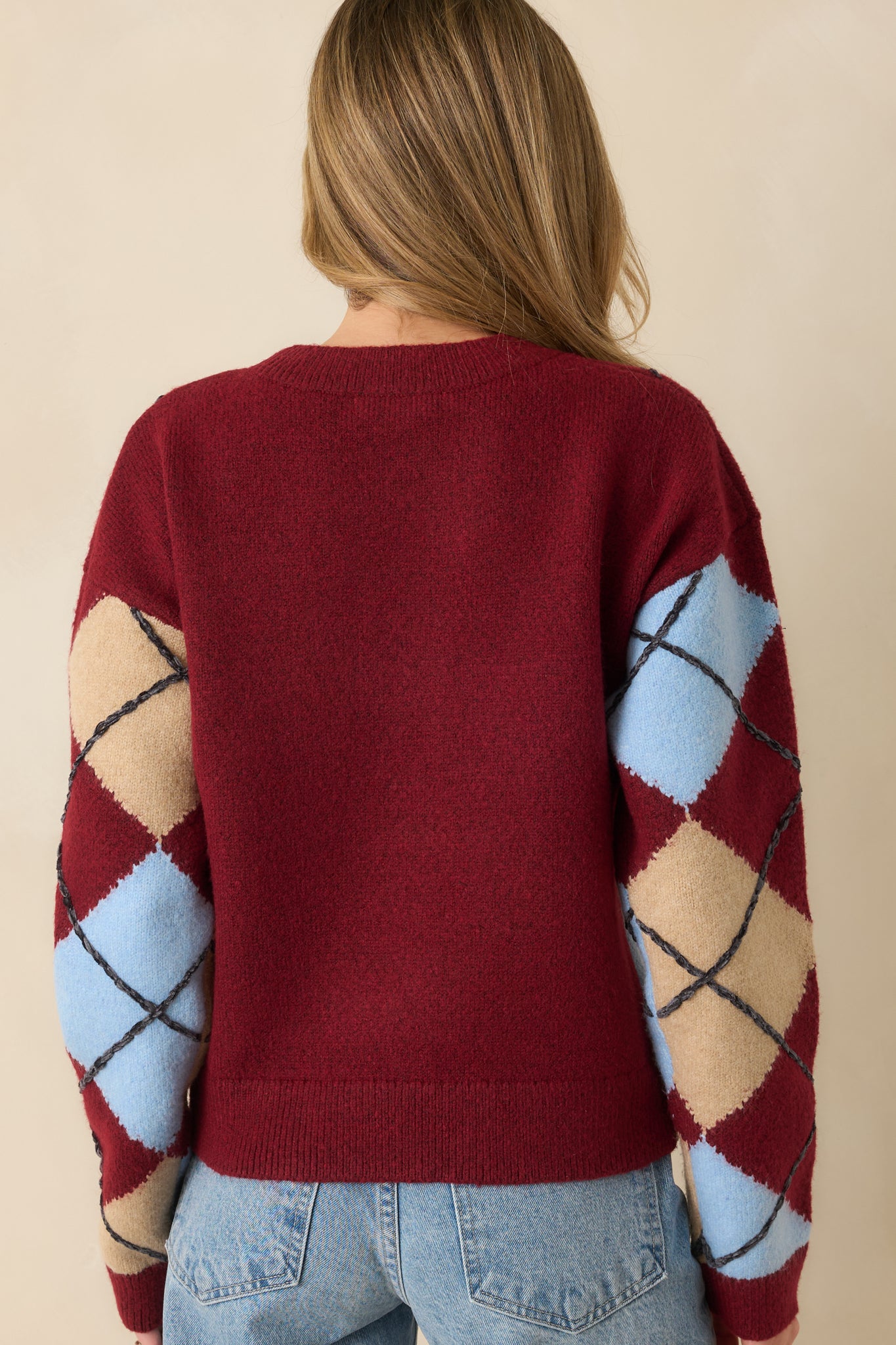 Back view of burgundy knit sweater showing solid color with ribbed hem and cuffs.