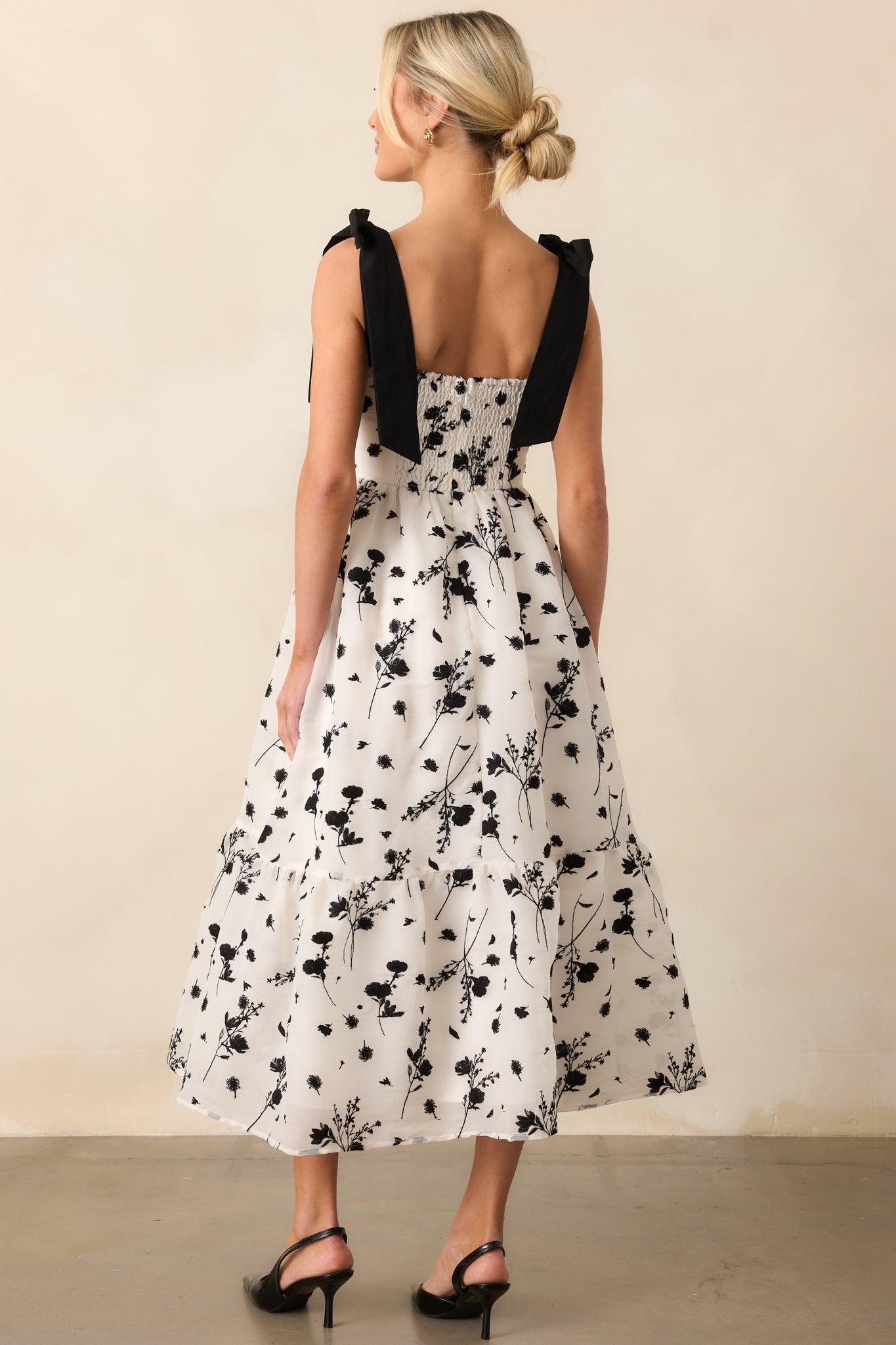 The back of the midi dress, featuring the smocked panel and self-tie bow straps, providing a comfortable and stylish finish.