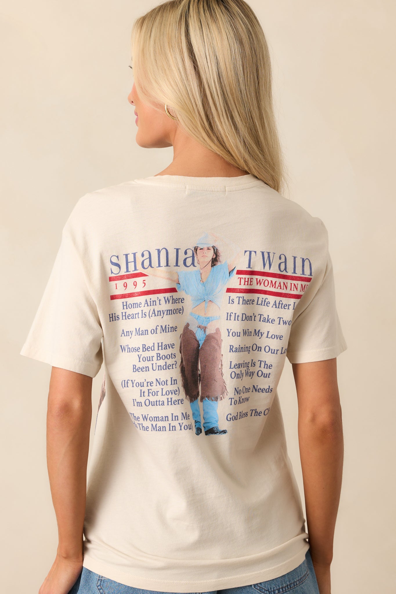 Back view of the ivory tee, showcasing the track list of the album printed on the back, with short sleeves and a crew neckline.