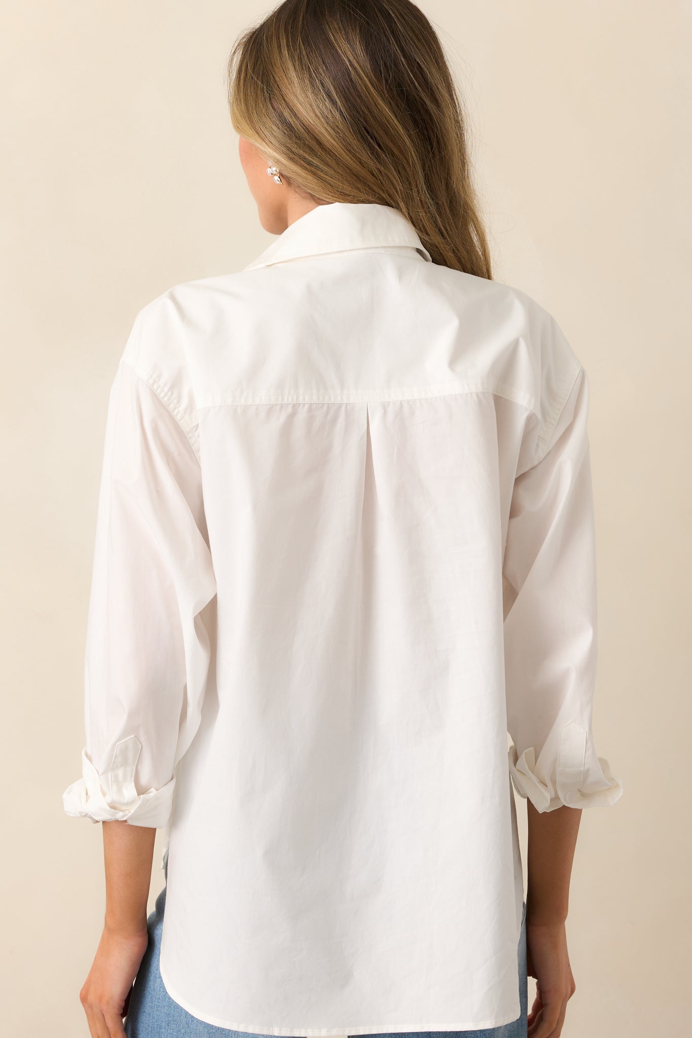 The back of this white top, showing its smooth fabric and tailored structure for a clean, polished finish.