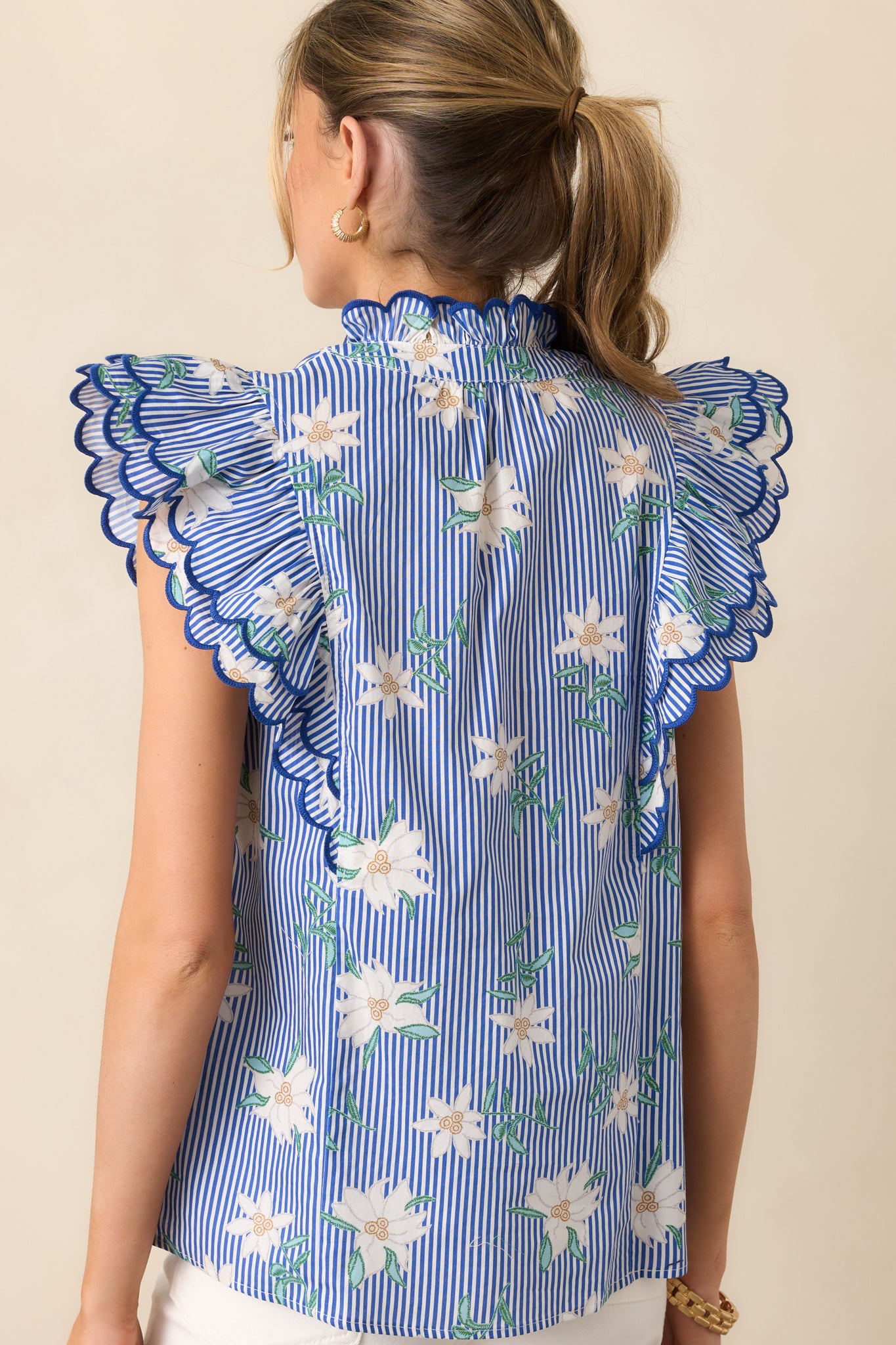 The back of the blue top, showcasing the continuation of the floral stripe print and the relaxed fit for effortless wear.