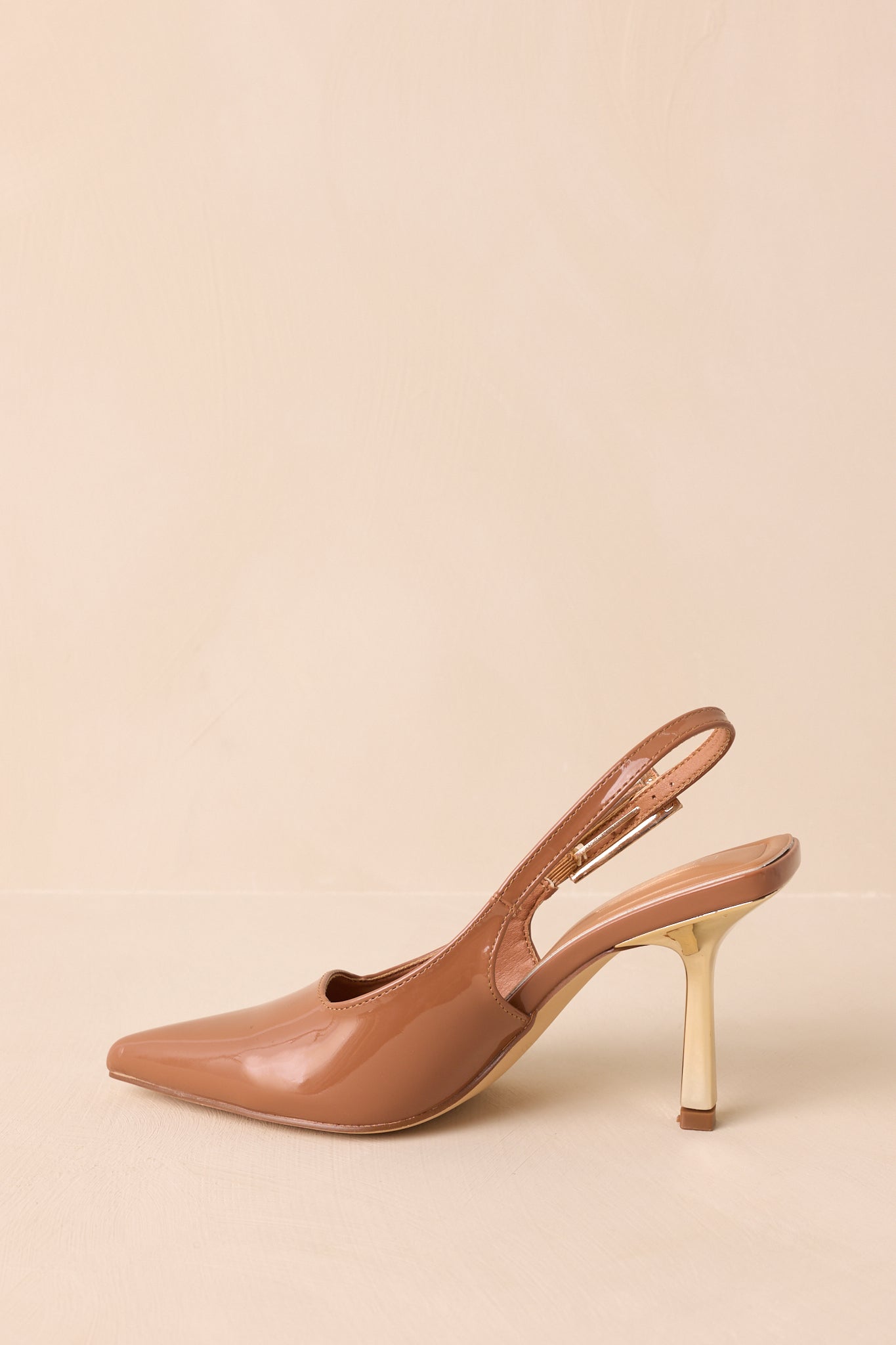 A side profile view of the brown slingback heels against a beige background, emphasizing the adjustable strap and block heel.