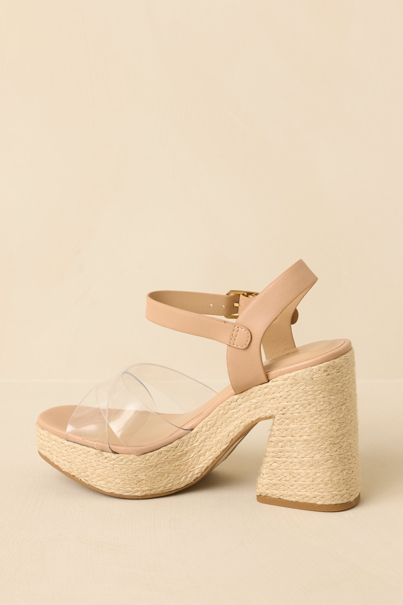 Back view of natural raffia platform sandals highlighting the raffia-wrapped block heel, platform sole, and adjustable ankle strap.