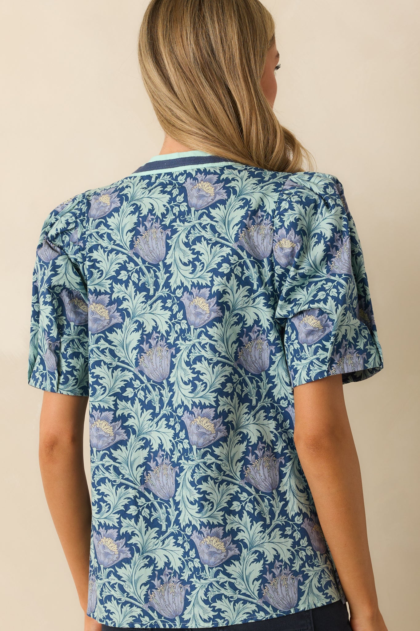 A back view of the top displaying the puff sleeves, relaxed fit, and allover floral print.