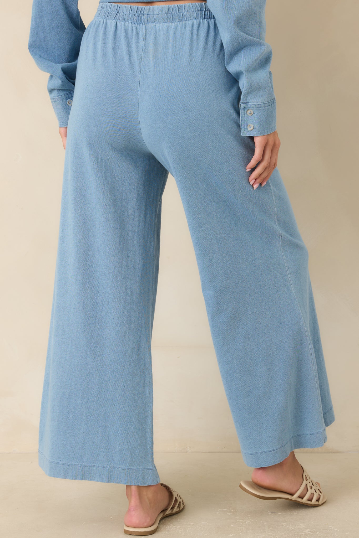 Back view of black wide leg pants featuring a relaxed fit and smooth silhouette.
