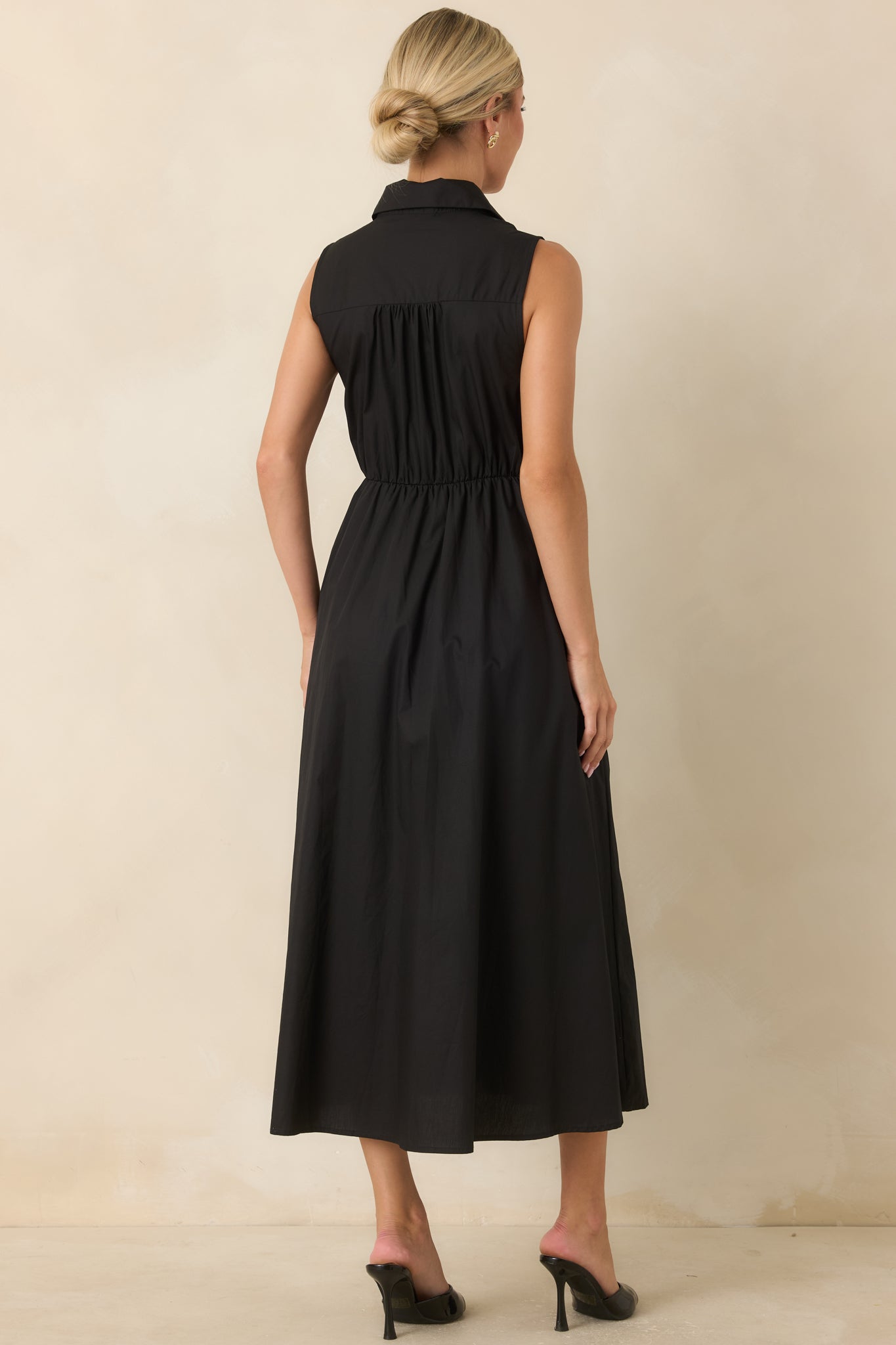 Back view of the cotton midi dress featuring a sleeveless silhouette and flowing gathered skirt.
