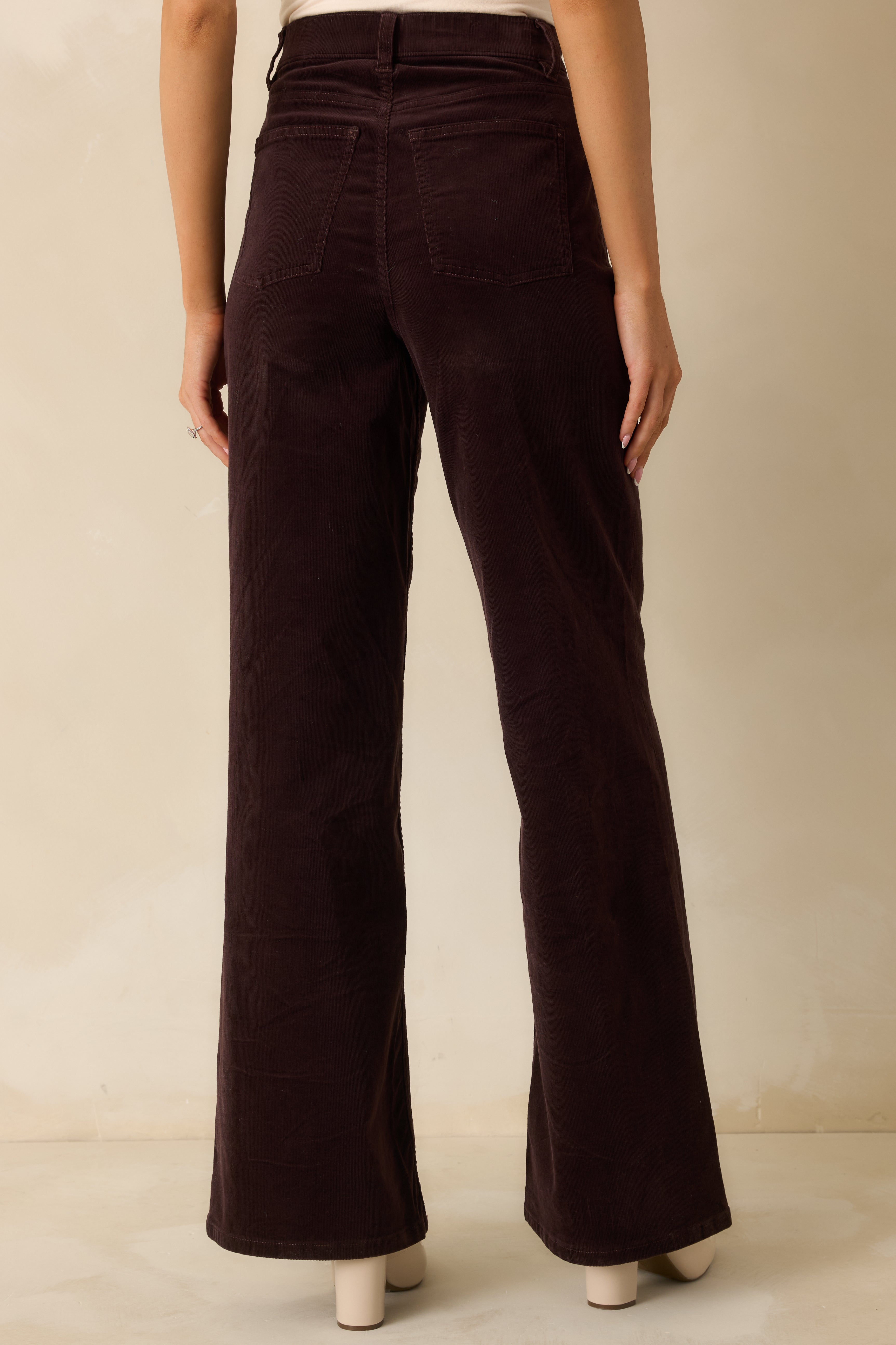 Rear view of dark brown corduroy jeans showcasing back pockets, high-rise fit, and wide-leg shape.