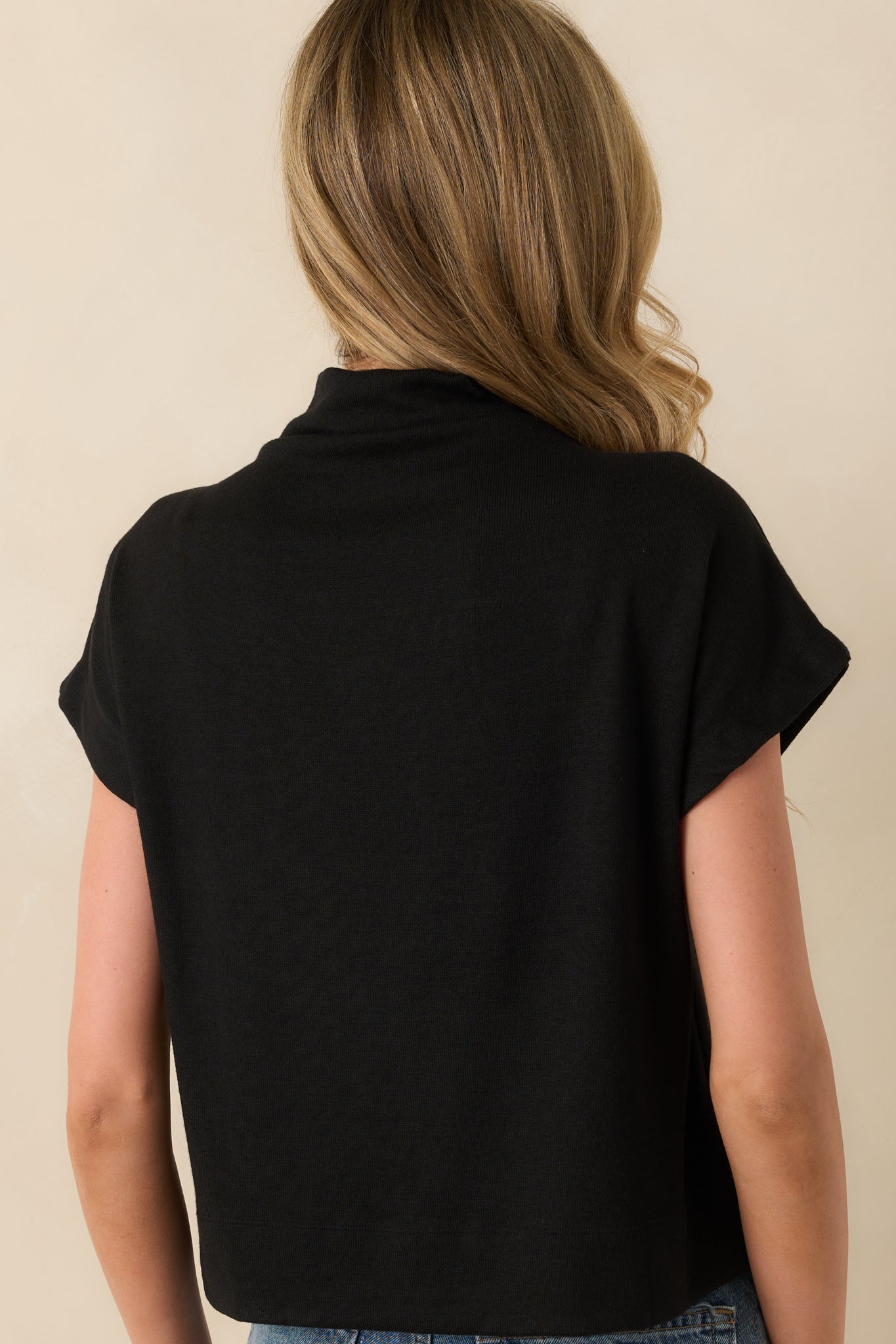 A back view of the top displaying the smooth back panel and relaxed fit continuing through the back hem.