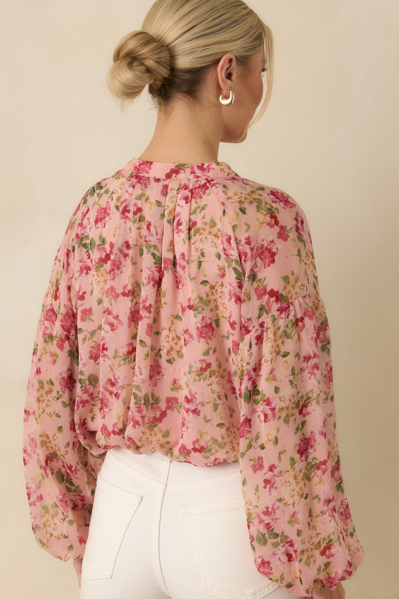 Back view of the sheer blouse displaying the back paneling, ballooned cuffs, and elasticized waist detail.