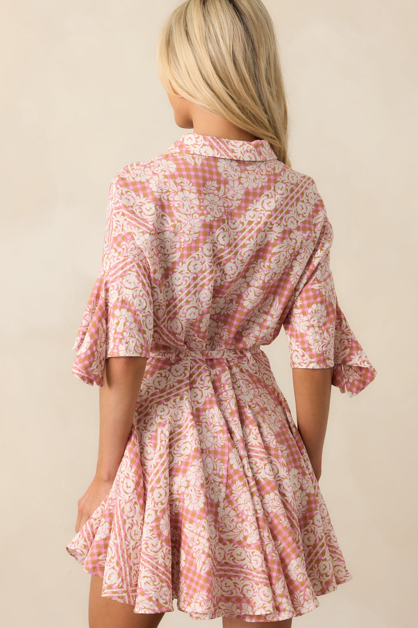 A back view of the dress displaying the seamless flow of the skirt and the continued gingham and floral pattern.