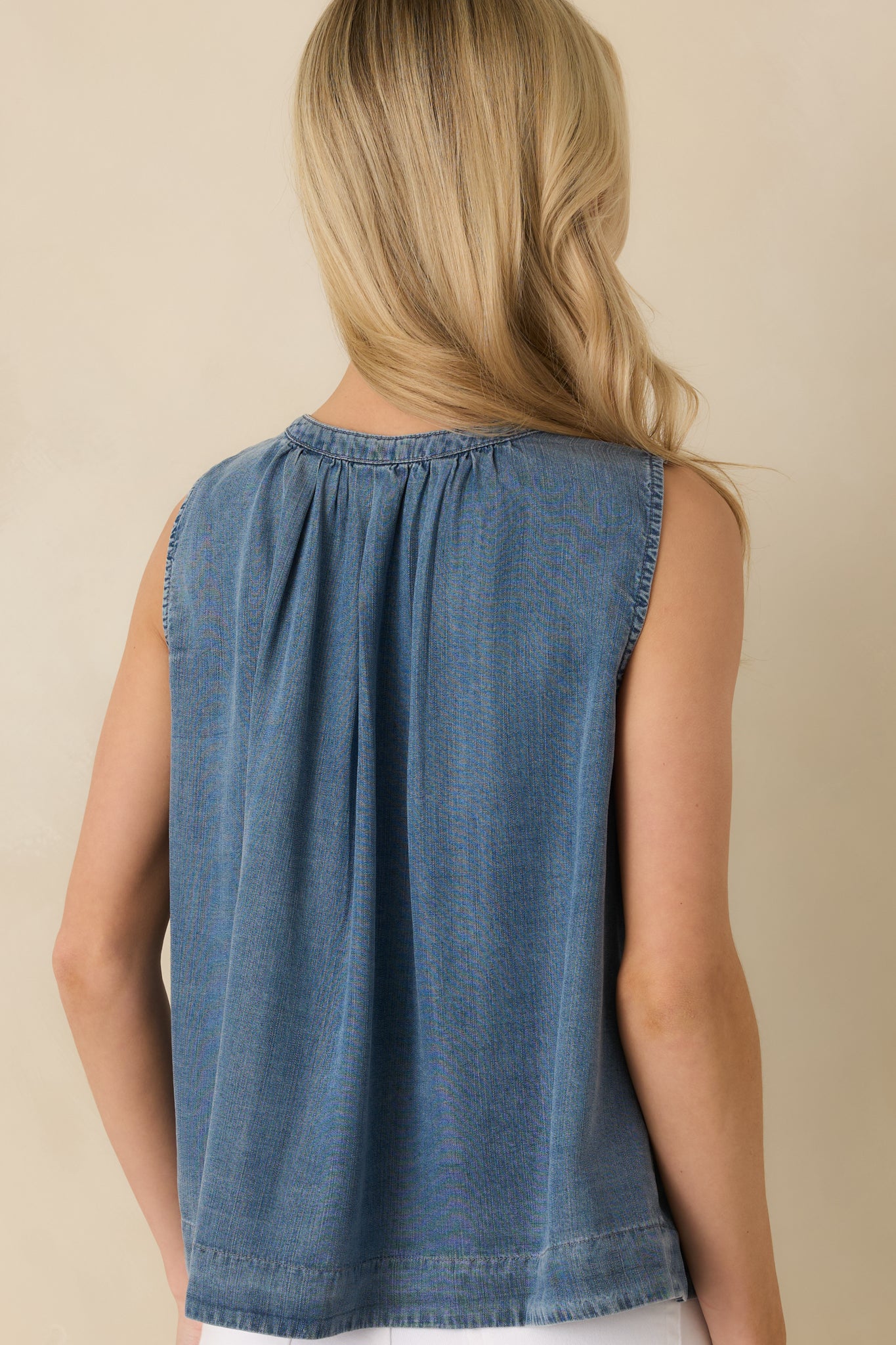 Back view of the sleeveless chambray top displaying smooth back fabric and relaxed fit.