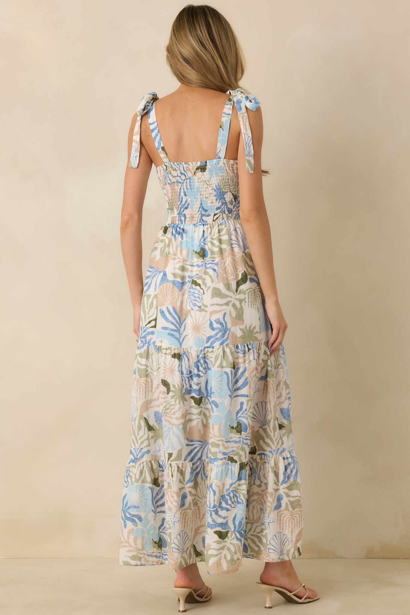 Back view of the blue multi maxi dress displaying the tiered skirt, smocked back bodice, and self-tie shoulder straps.