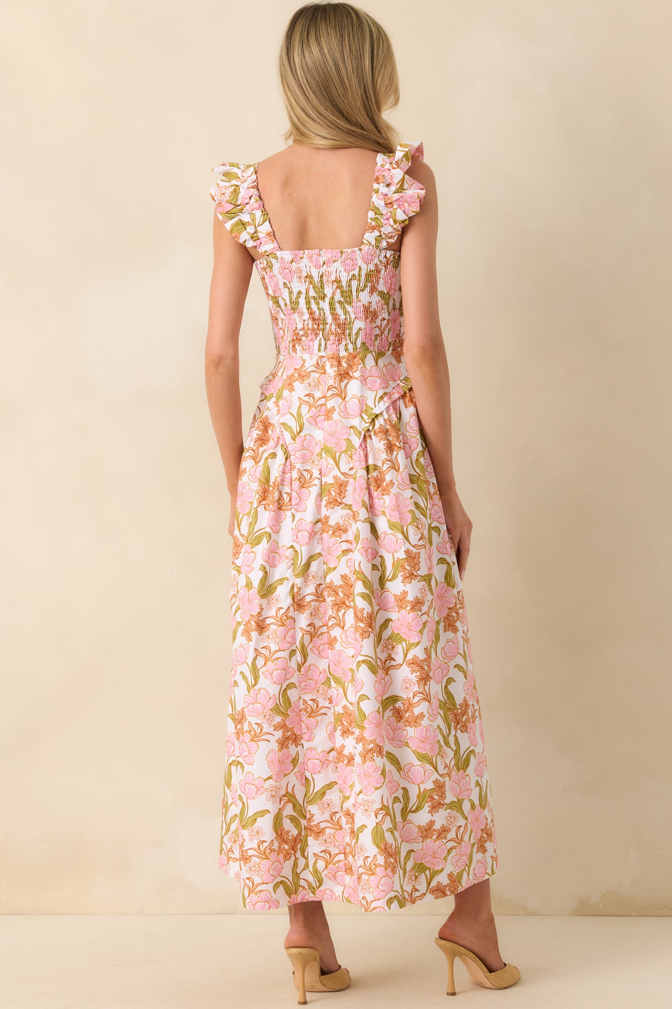 Back view of the dress showing the smocked panel, hidden back zipper, and continuation of the floral print across the full length.