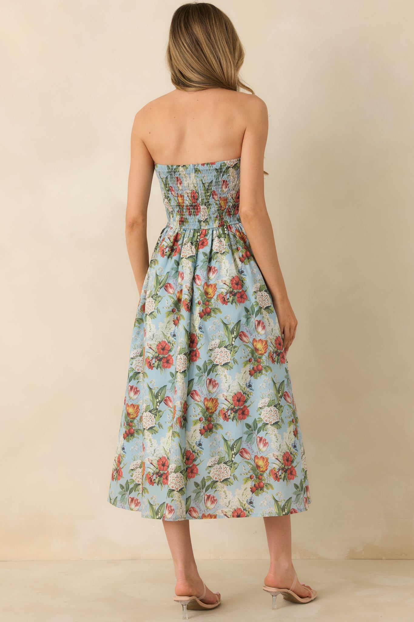 Back view of the blue floral dress featuring a smocked back panel and hidden zipper closure.